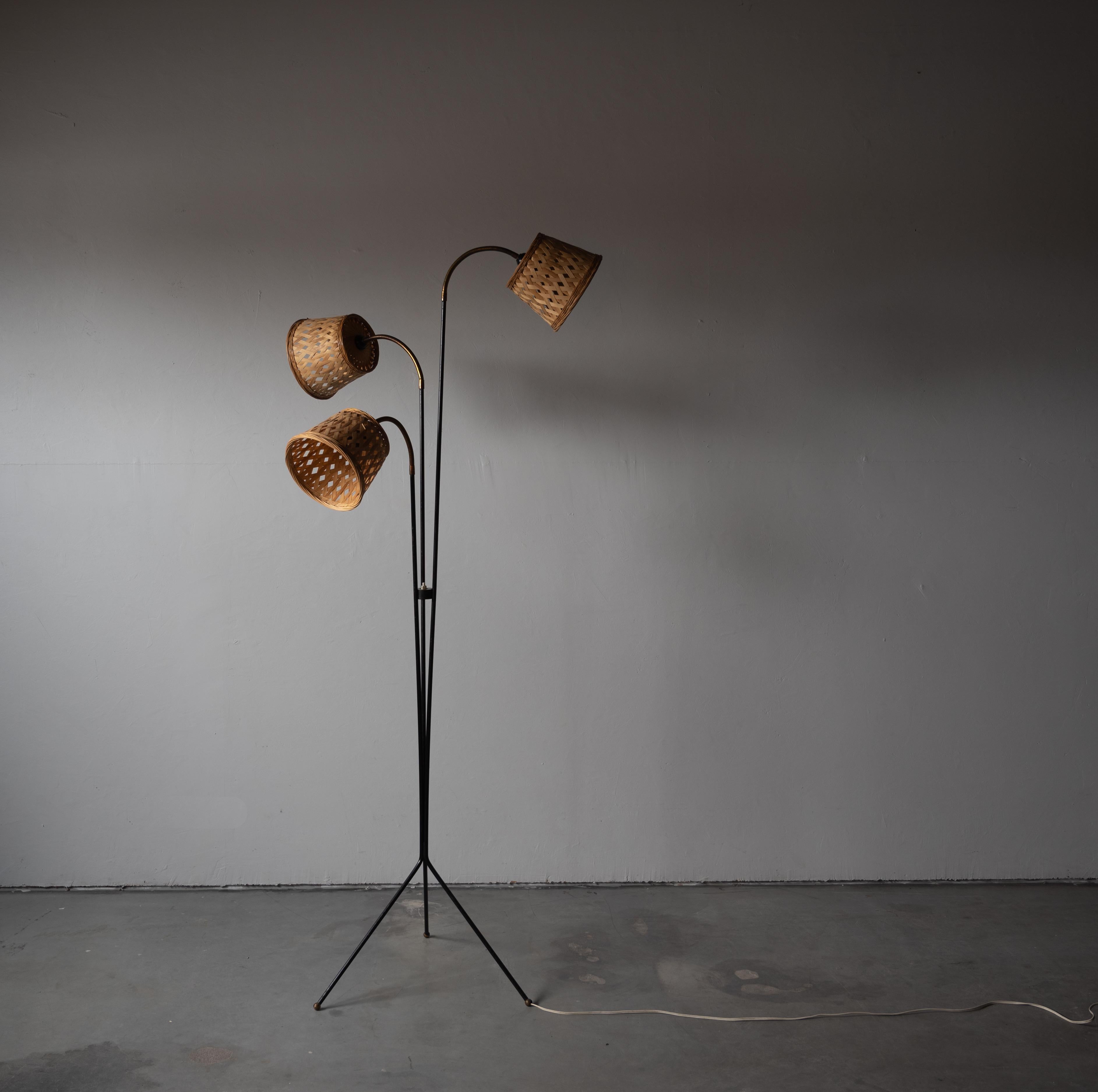 An adjustable three-armed floor lamp, designed and produced by Svend Aage Holm Sørensen, Denmark, 1950s. With black lacquered metal, brass, assorted vintage rattan lampshades.

Other designers of the period include Paavo Tynell, Serge Mouille,