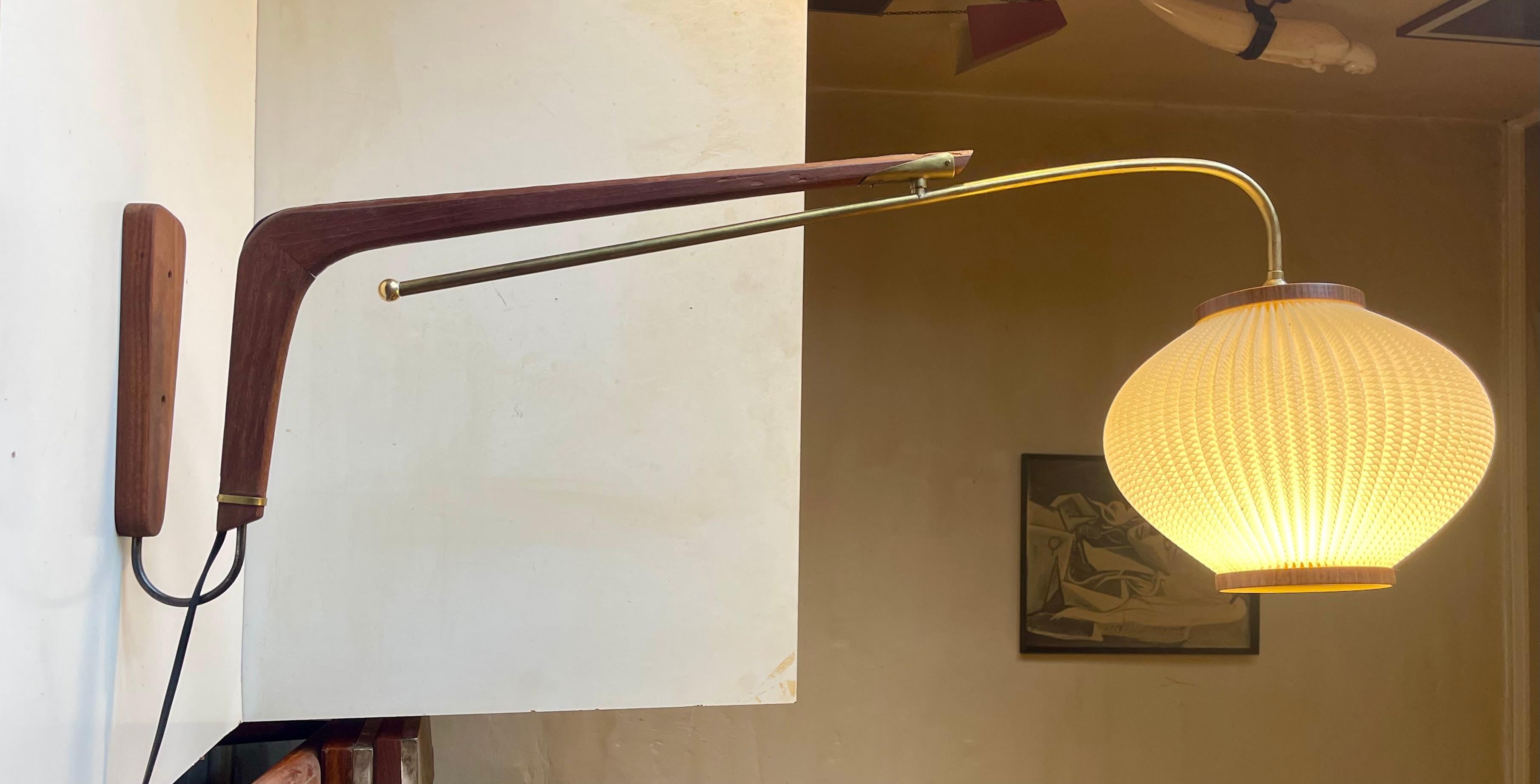 A rare large adjustable swing-arm wall sconce made from solid teak, brass components and an acrylic beehive shade. 180 degrees adjustable and adjustable at the shade. It was designed during the 1950s by Svend Aage Holm-Sørensen and made by his