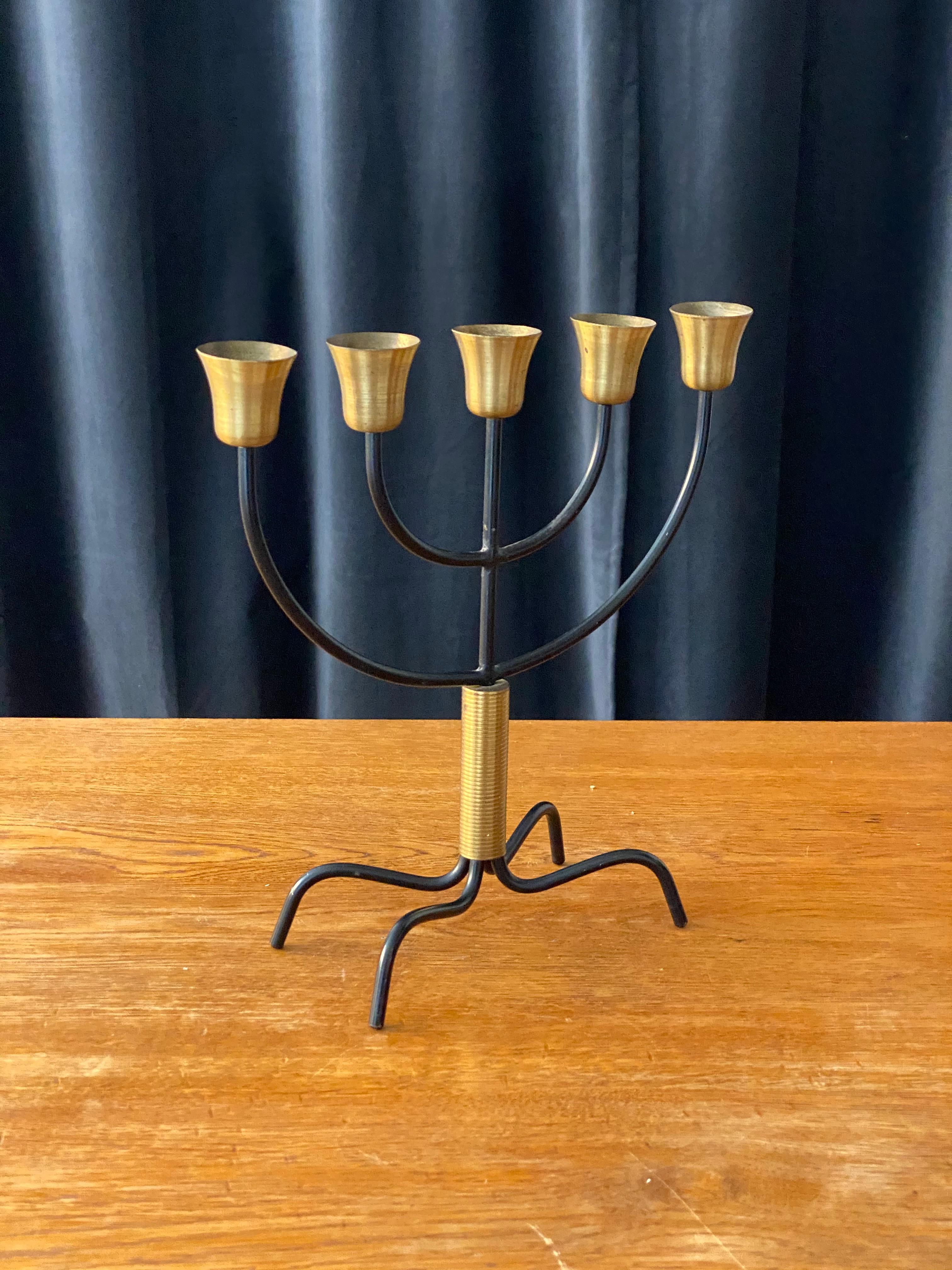 A rare 5-armed candelabra, designed by Svend Aage Holm Sørensen. Produced by Holm Sørensen Co, Denmark, 1960s. In brass and organically shaped, black lacquered metal. Markings engraved. 

Other lighting designer of the period include Paavo Tynell,