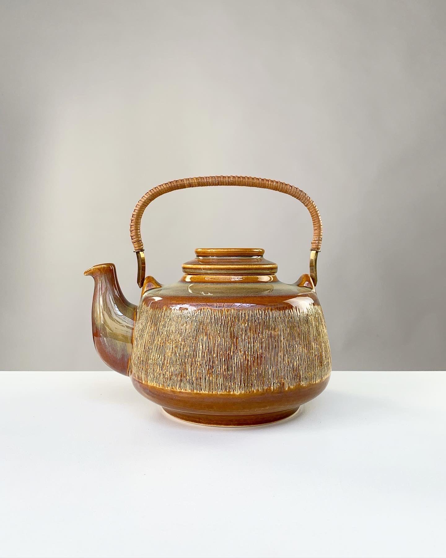 Beautiful teapot by Svend Aage Jensen from the ‚Manilla‘ series - a range of pottery pieces in sgraffitto technique with a glaze shining like mother of pearl.

Manufactured by Søholm in Denmark in the 1960s.

Solid brass handle with wicker