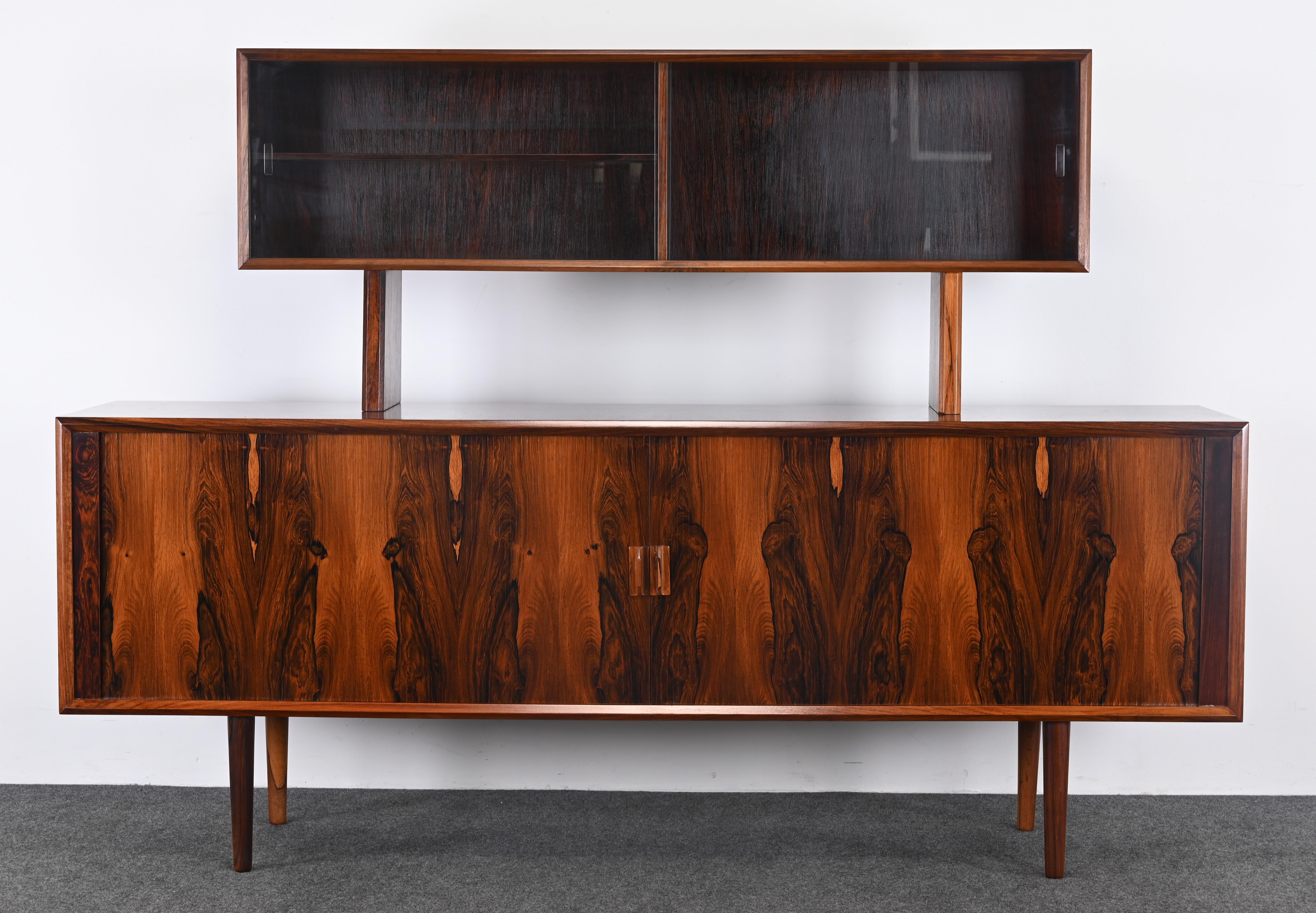 Una splendida credenza con vetrina in palissandro di Svend Aage Larsen per Faarup Møbelfabrik. Questo bellissimo mobile ha un ampio spazio di archiviazione e un design elegante e classico. La credenza ha il retro rifinito in palissandro che può