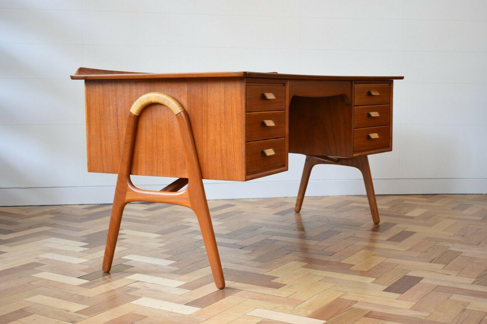 This beautiful and rare teak desk is design of Svend Aage Madsen, manufactured by Sigur Hansen Møbelfabrik in the 1950s.

The gorgeous piece is characterised by its curved shape and features bamboo detailing on both the legs and draw handles. With