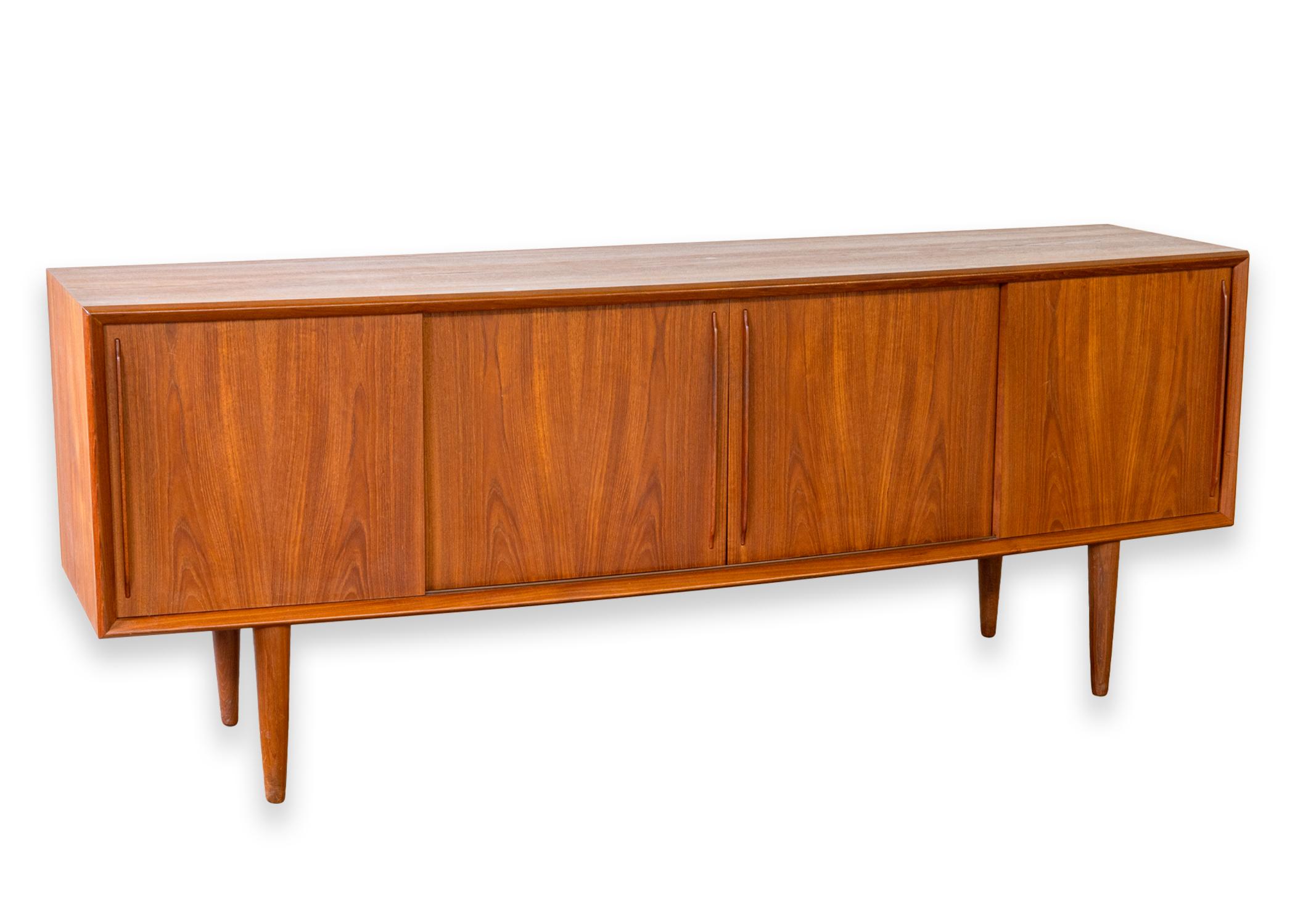A Danish teak wood credenza. This is an absolutely gorgeous piece designed by Svend Aage Madsen for H.P. Hansen Mobelindustries in the 1960s. This piece is a truly remarkable statement that has stood the test of time. It is equal parts function and