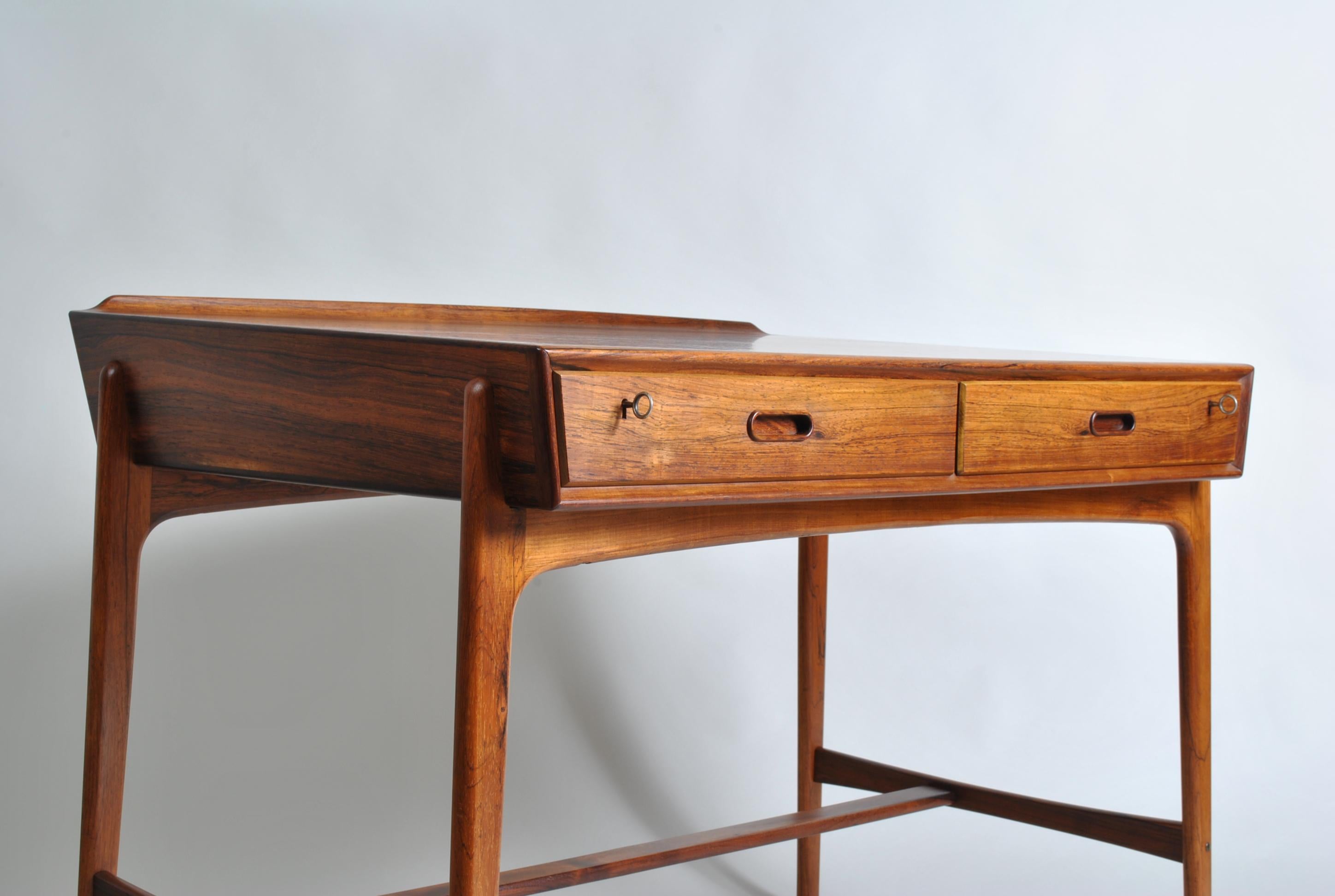 A rosewood Svend Aage Madsen desk produced by Sigurd Hansen in Denmark, 1958. A remarkable design by Madsen and beloved by collectors worldwide. Such beautiful shapes and details on what is an extremely practical piece of furniture. Superb