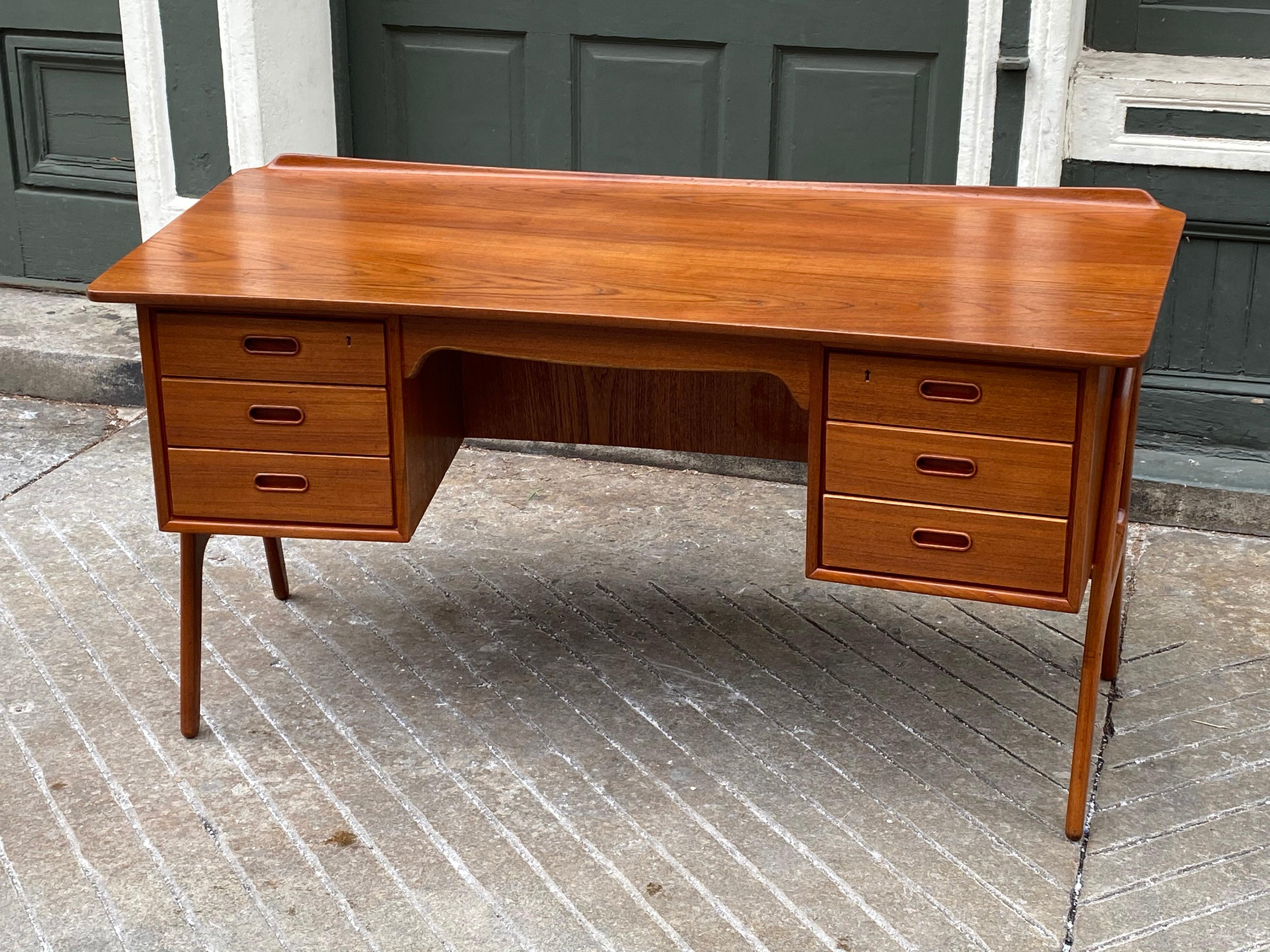 Svend Aage Madsen for Sigurd Hansen teak desk with front bookcase. Desk has a slight graceful curve with a rolled edge to the back of the desk. Beautiful size and scale! Legs are exposed on each end to add to the visual impact of the Desk! Desk has