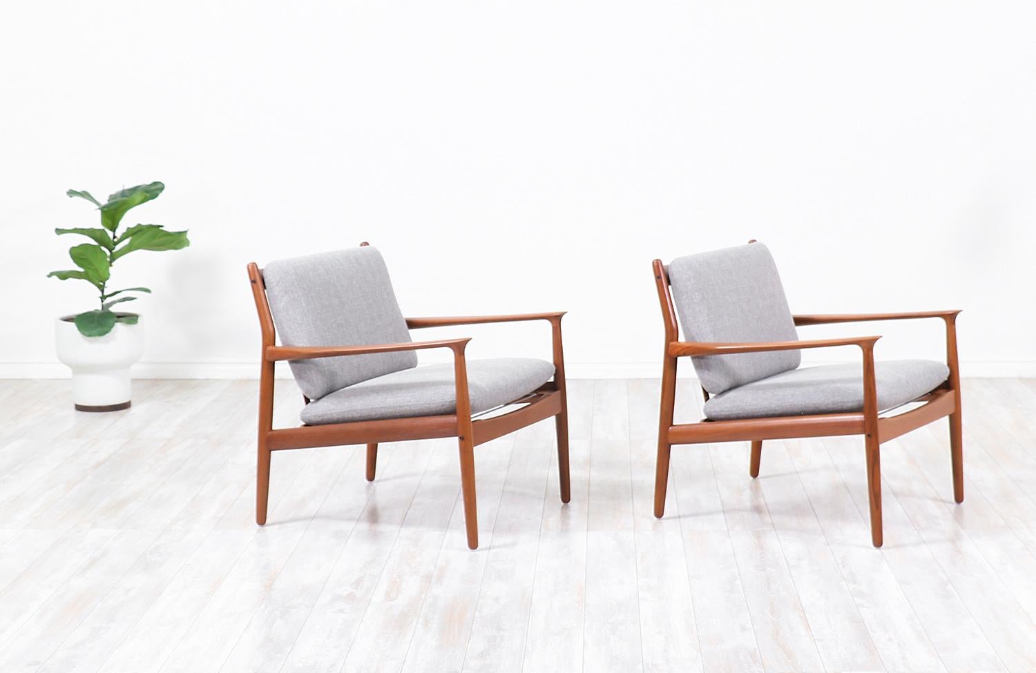 Pair of sleek modern lounge chairs designed by Svend Åge Eriksen and manufactured in Denmark by Glostrup Møbelfabrik circa 1950s. These beautiful Model GM-5 lounge chairs feature a solid teak wood frame and sculpted armrests that showcase