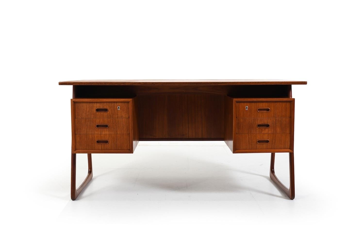 Freestanding teak desk by Svend Åge Madsen for HP Hansen Denmark 1960s. With 3 drawers each site, sled legs and front with book compartment. Key incl.
