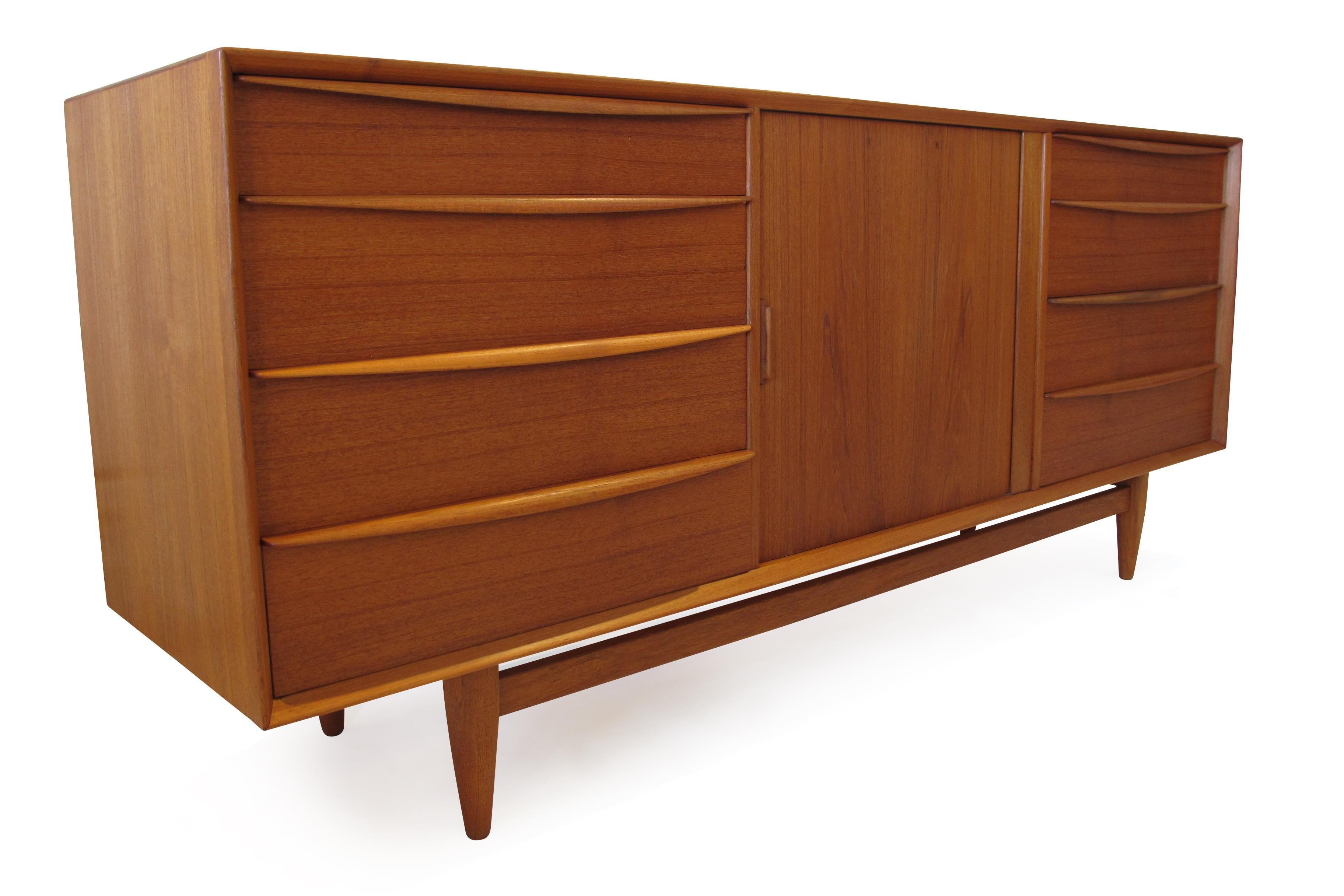 Midcentury teak dresser designed by Svend Age Madsen for Falster Mobelfabrik, Denmark. Crafted of old-growth teak with mitered corners, and raised on round tapered legs. The dresser has a total of 13 drawers. The left and right sides features four