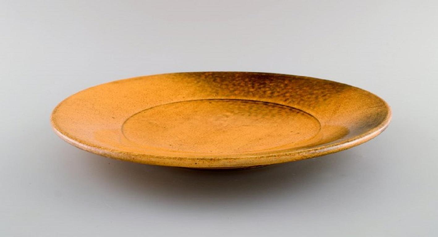 Svend Hammershøi for Kähler, Denmark. 
Large bowl / dish in glazed stoneware. 
Beautiful yellow uranium glaze. 1930s / 40s.
Measures: 32.5 x 4 cm.
Signed.
In excellent condition.