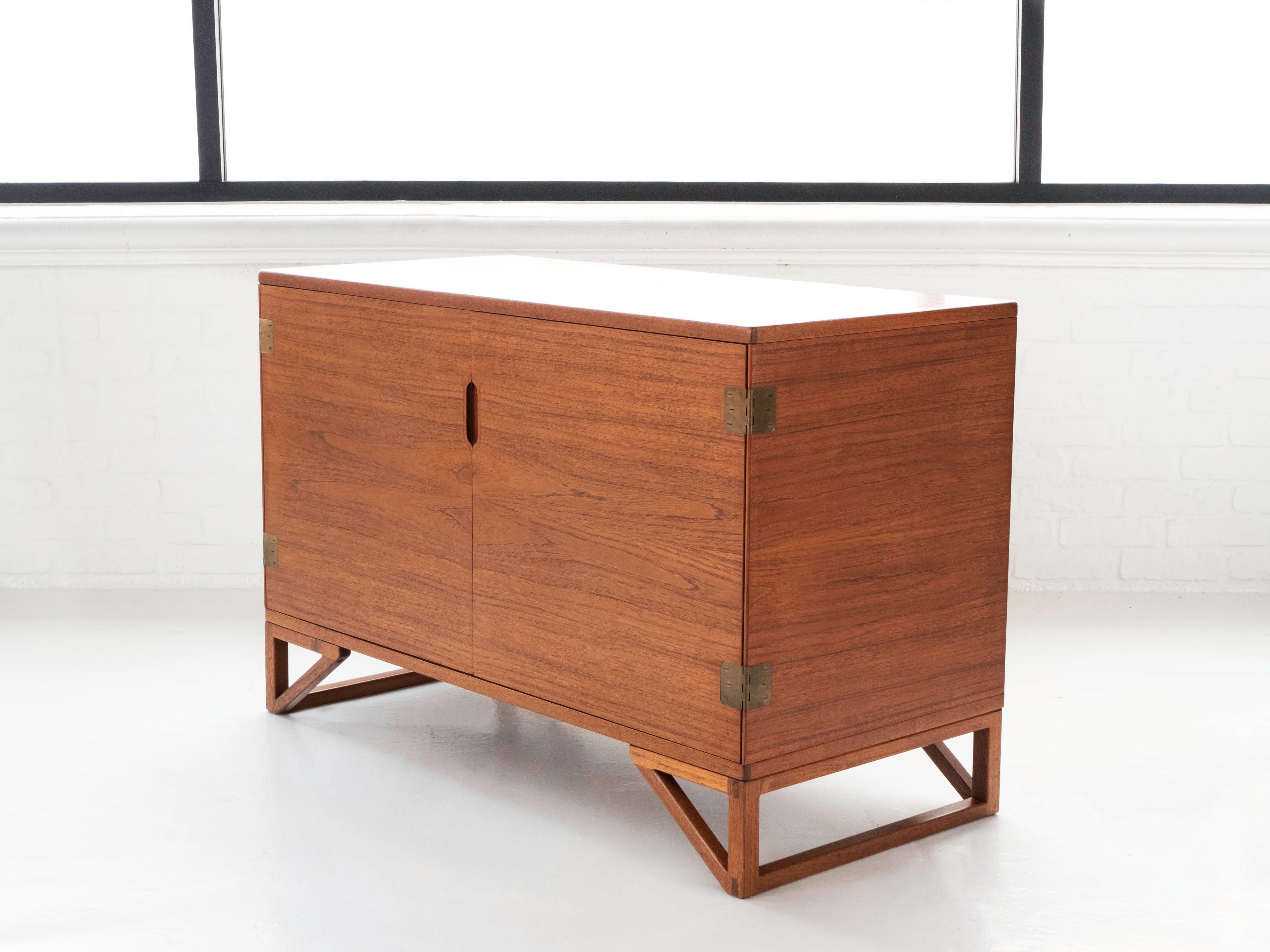 Svend Langkilde petite cabinet for Illums Bolighus.  Produced by Langkilde Mobler, Denmark 1960's.

The teak wood grain is bookmatched on all sides.  The interior of this two-door cabinet includes 4 pull out drawers on one side, with adjustable