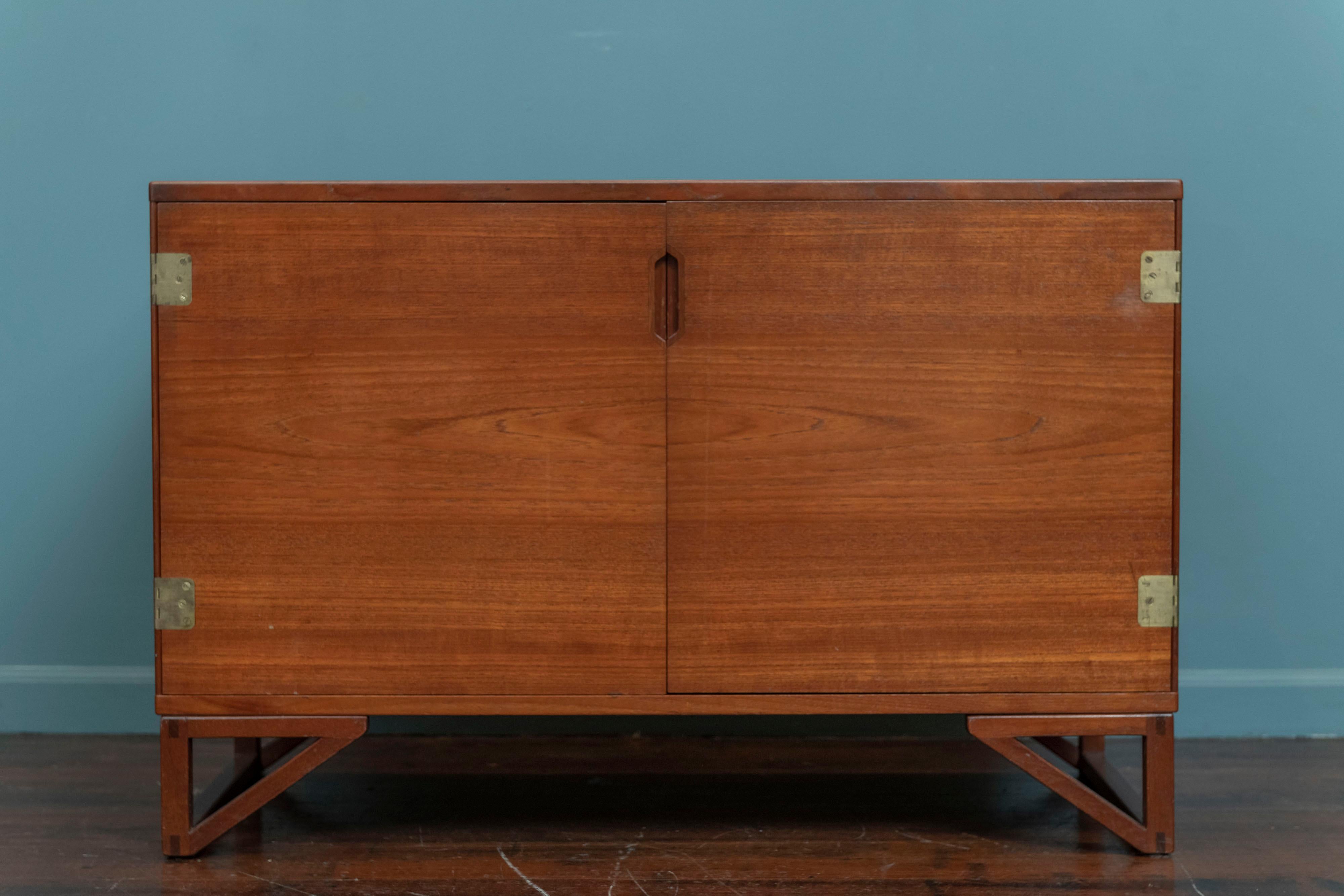 Svend Langkilde design two door teak cabinet for Langklide Mobler, Denmark. High quality construction and use of materials, featuring two doors with inset brass hinges and a fitted adjustable interior. In very good original condition that is ready