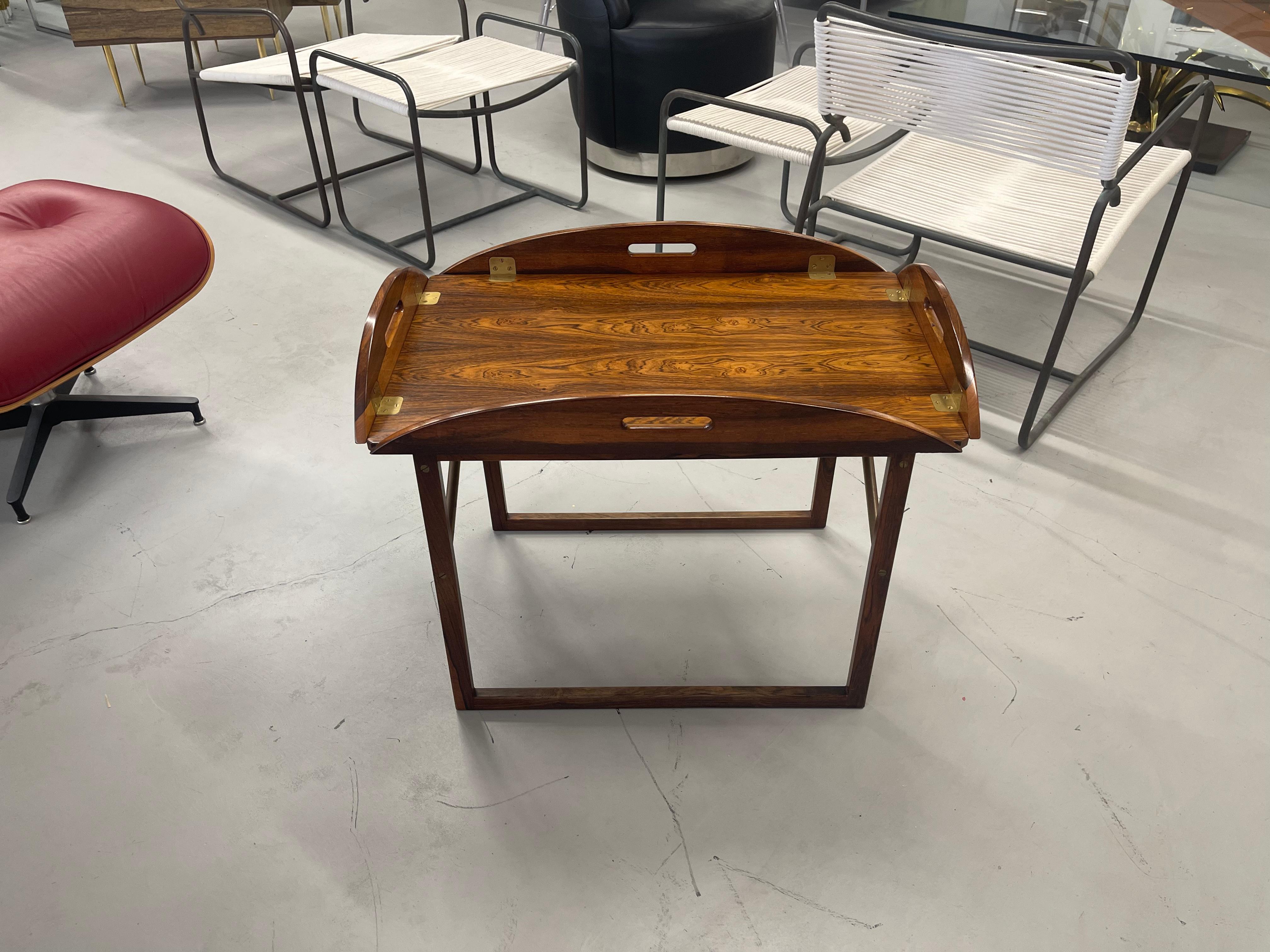 A stunning 1960's rosewood butler's tray table by Svend Langkilde. Beautiful top. Have to say the graining on this example is one of the most striking. Tray top is removable. Brass cross stretcher on the sides of the base. Quite stable. Tray top