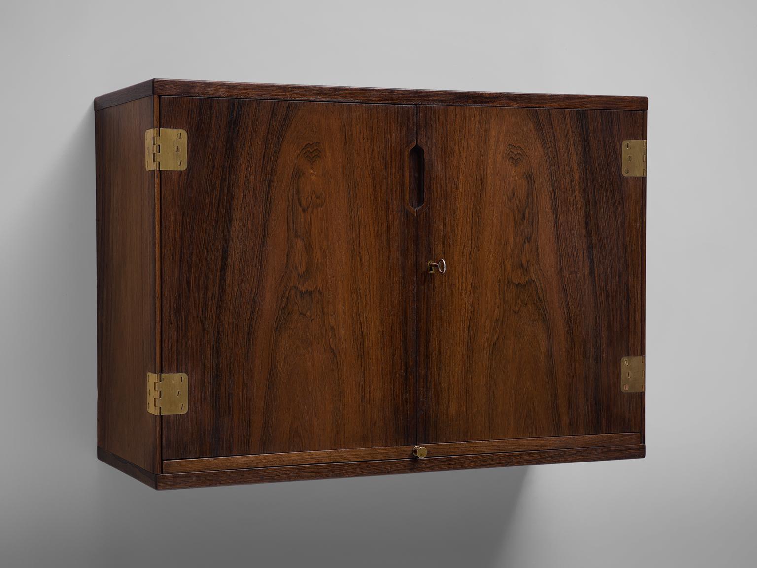 Svend Langkilde, wall-mounted bar cabinet, rosewood and brass, Denmark, 1960s.

This versatile bar cabinet designed by Svend Langkilde, features a beautiful rosewood grains. The book-matched rosewood doors open on fine brass hinges to two