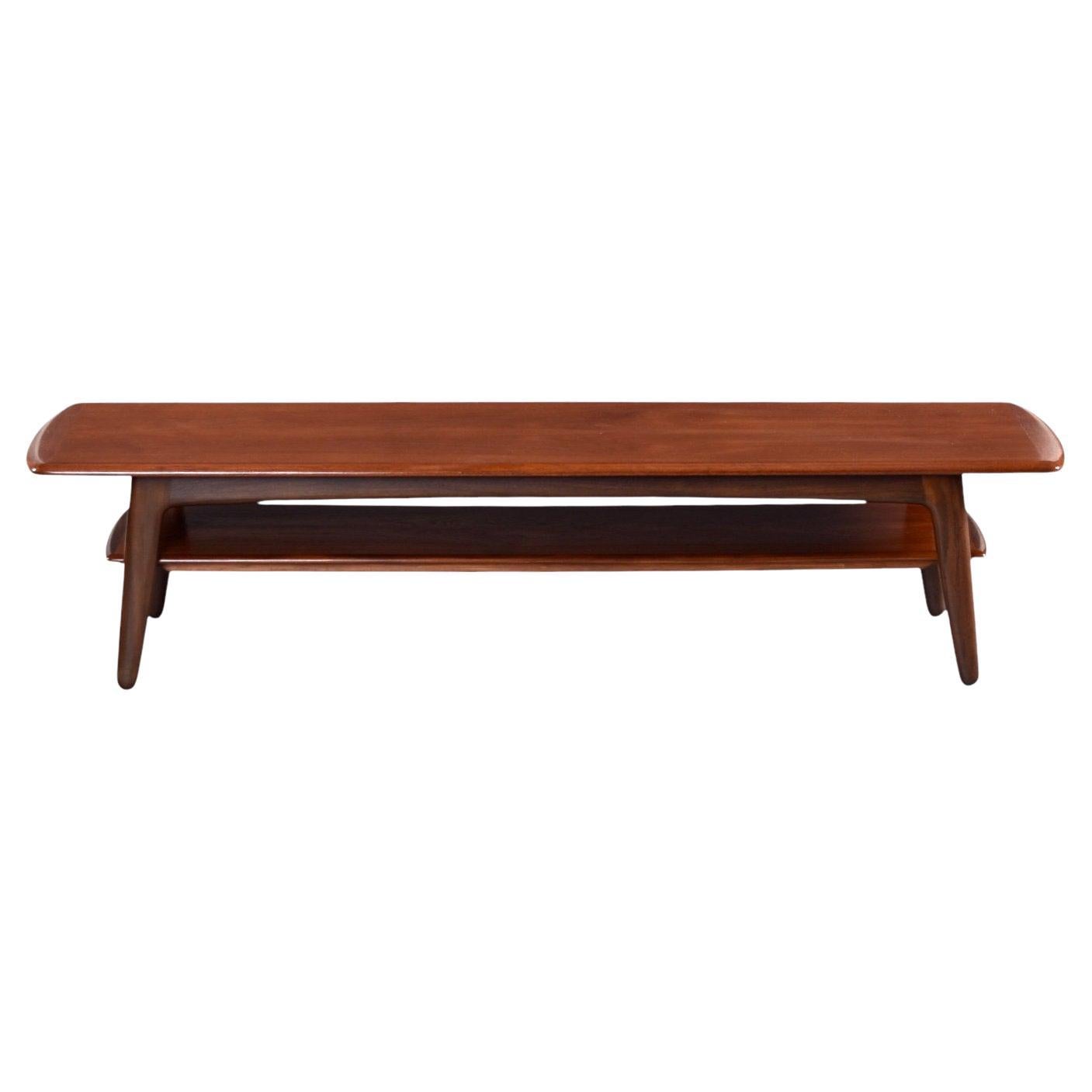 Gorgeous, large Danish teak coffee table produced by Svend Madsen. The Mid-Century Modern coffee table features elegant styling and expert Scandinavian craftsmanship. The solid teak wood legs are a bit thicker than typically seen on Danish