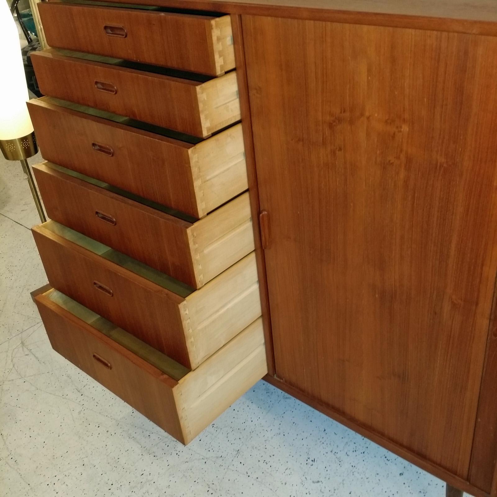 Falster wardrobe cabinet/dresser in beautiful original vintage condition throughout.
Crafted in Denmark, teak and birch interior drawers behind tambour door.