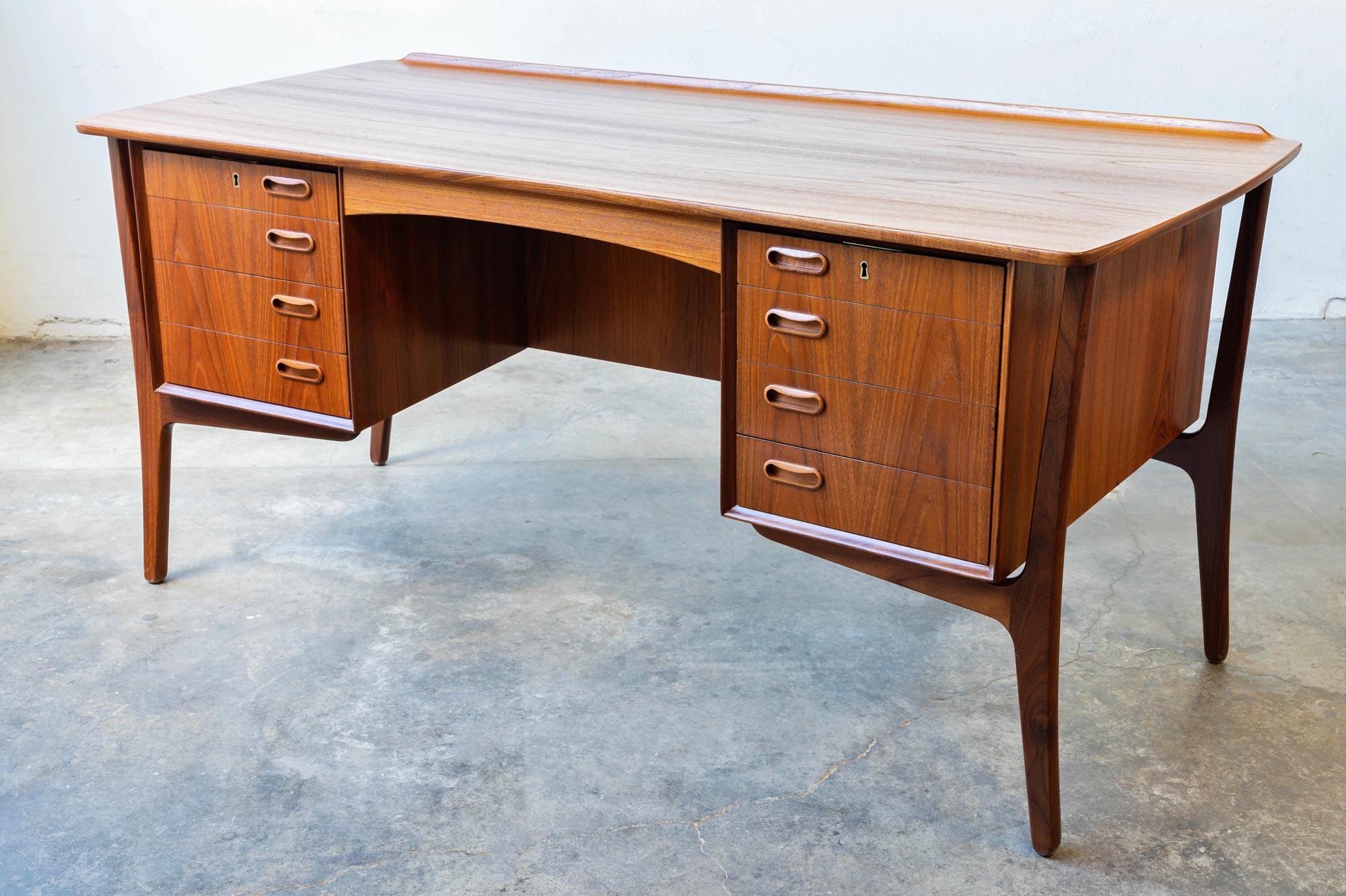 Upgrade your workspace with the Svend Madsen for HP Hansen teak executive desk. Designed by the renowned Danish furniture designer Svend Madsen, this beautifully refinished desk is the perfect blend of style and practicality.

Crafted from