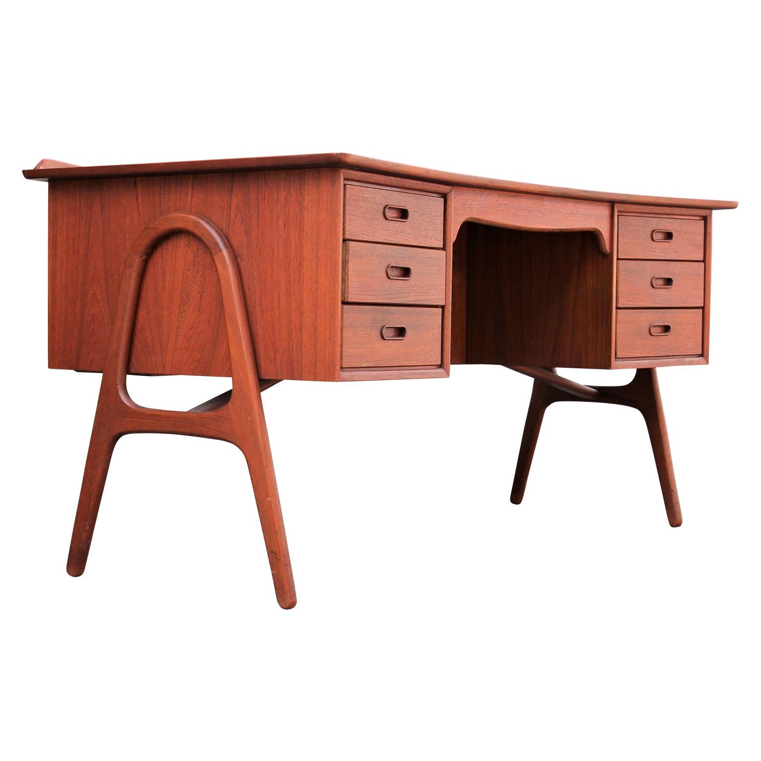 Beautiful sculptural teak desk, model SH 180, designed by Svend Aage Madsen and made in Denmark by Sigurd Hansens Mobelfabrik. This ergonomically curved desk has six drawers, a large work space with a raised lip, and an open shelf in the front.