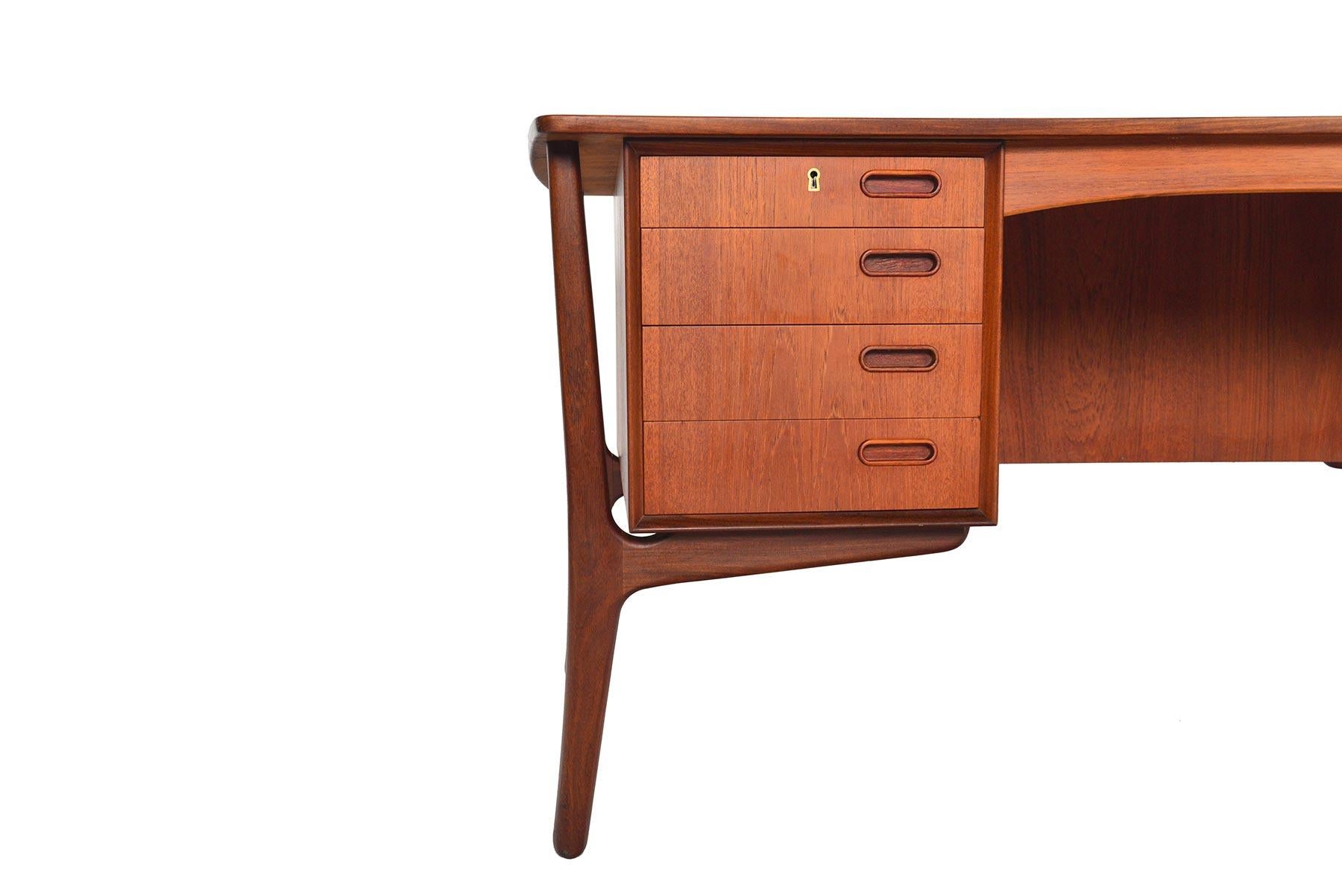 A staple of Scandinavian design, this teak executive desk was designed by Svend Madsen as Model 20 for H.P. Hansen in the 1960s. The top plate offers a subtle bowed design with an exterior raised. Exterior mounted legs not only support the table