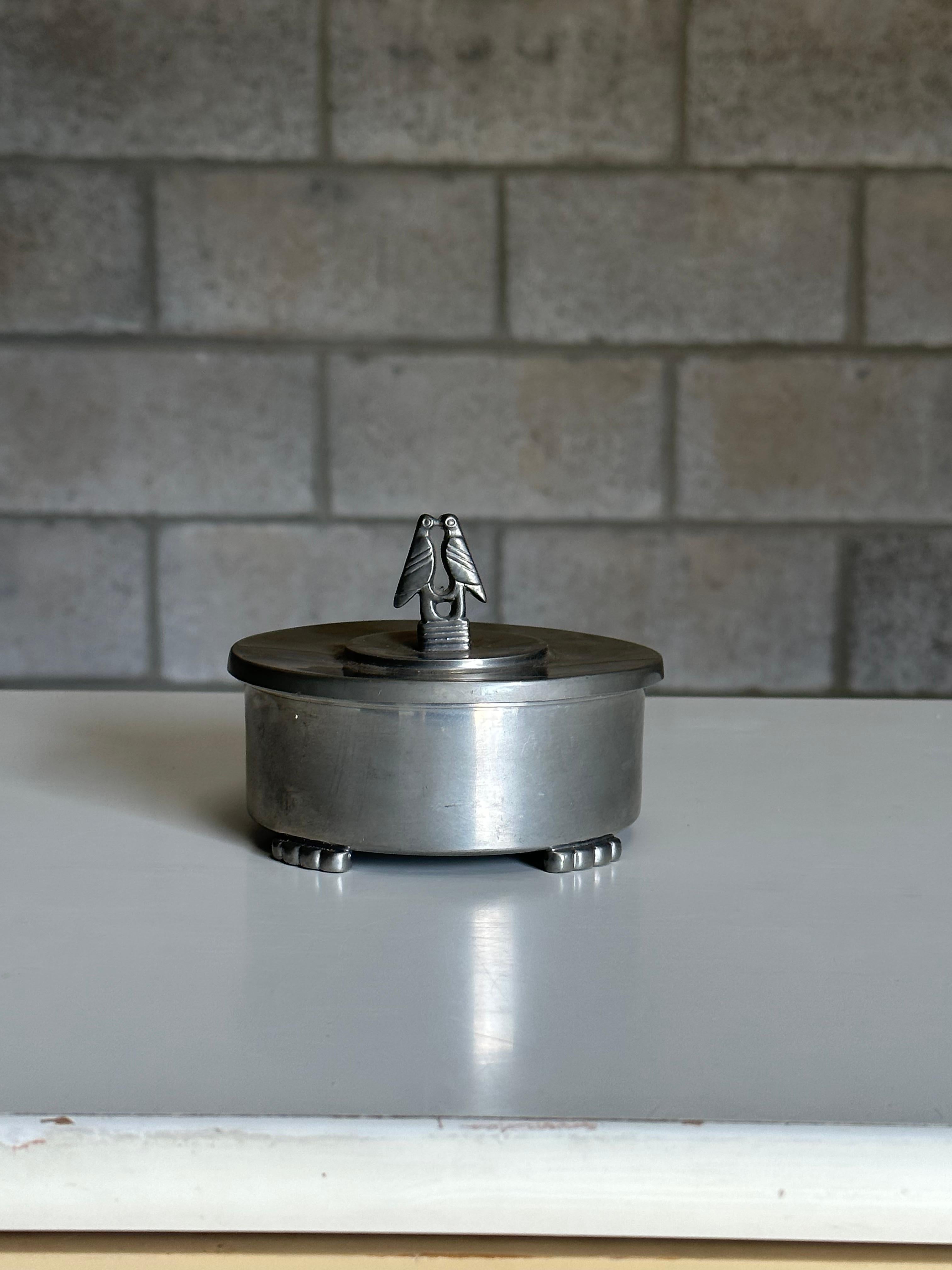 An iconic Art Deco lidded jar or container produced by Firma Svensk Tenn circa 1930s. Executed in pewter, it maintains a minimalist design with Art Deco touches.