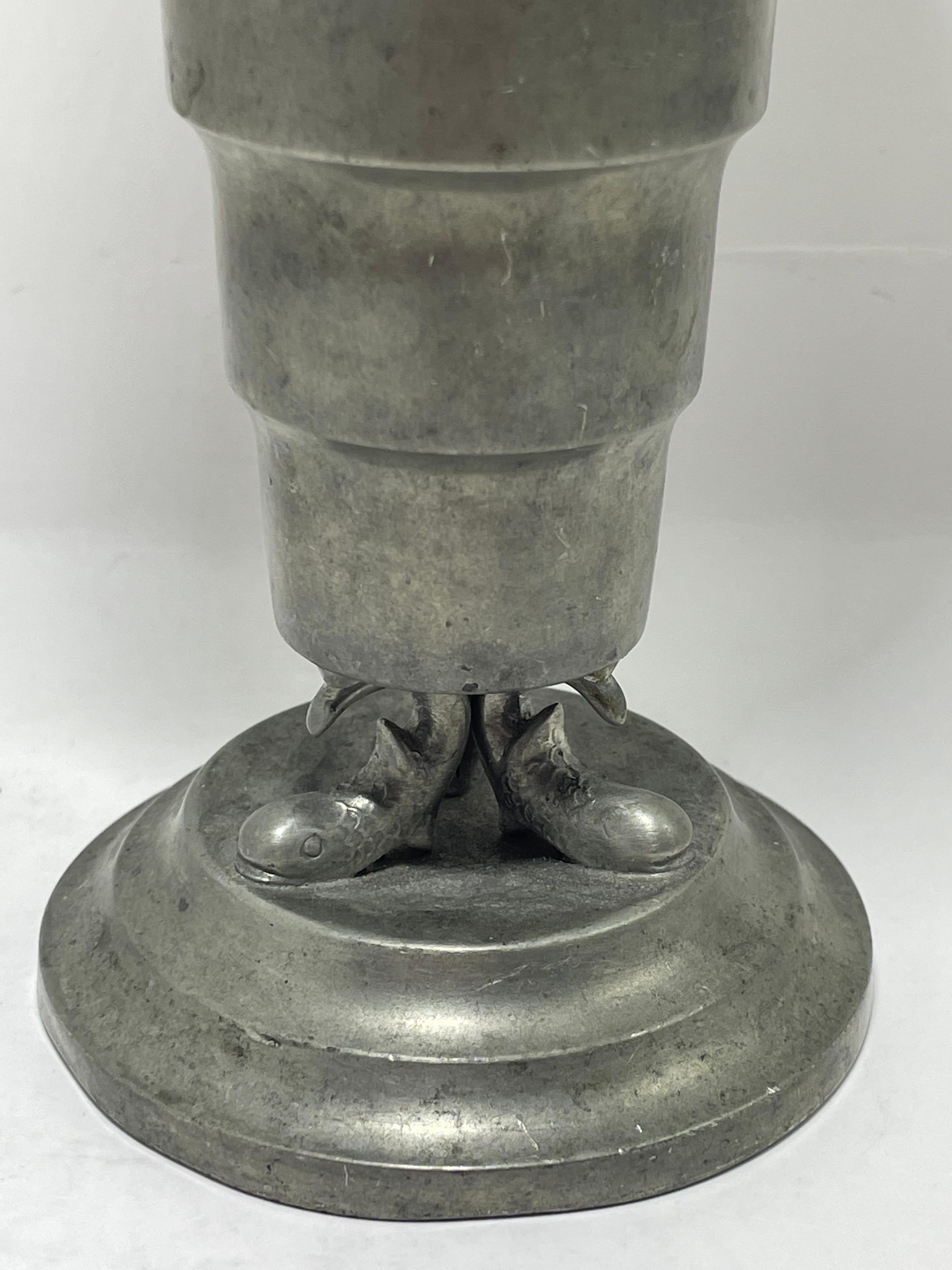 Un sorprendente vaso in peltro Art Déco progettato e realizzato da Svenskt Tenn, Svezia, circa 1935. Questo elegante pezzo presenta un corpo a gradini con un bordo svasato e poggia su una base scultorea con dettagli organici stilizzati, fondendo la