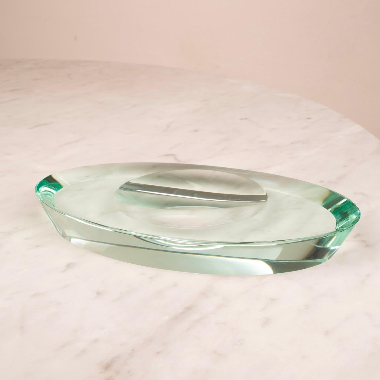 Refinada y elegante bandeja para aparcacoches de cristal verde Nilo, diseñada en 1960 por Max Ingrand para Fontana Arte, uno de los fabricantes de cristal e iluminación más emblemáticos de Italia.

Esta pieza escultórica ejemplifica la elegancia