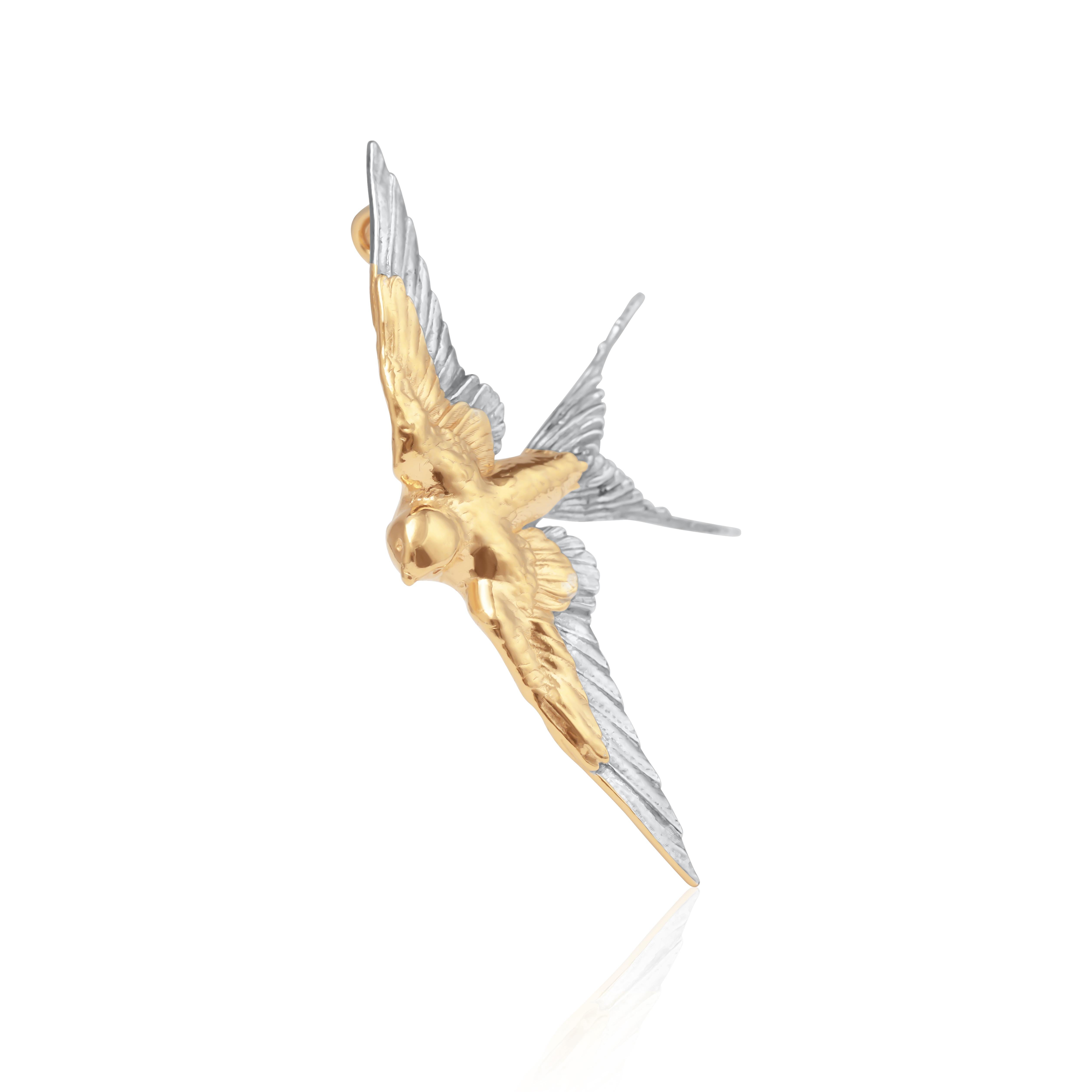 Ce pendentif gracieux représente une hirondelle en plein vol, fabriquée en argent sterling et finie avec un vermeil en or 24 carats très poli. La forme dynamique de l'oiseau capture l'élégance et le symbolisme de la liberté et de l'amour. De