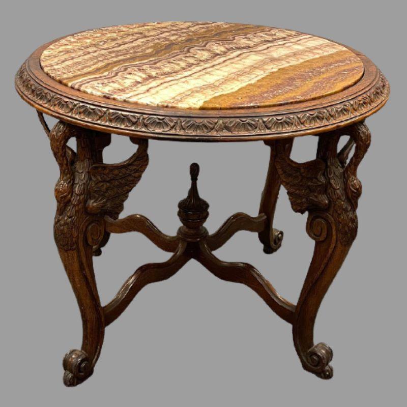 A finely carved center table possibly by Horner or Herter brothers. This Louis XV style carved center or large coffee table has a wonderfully carved apron supporting a circular marble top. The base having four carved full bodied swans. Circa 1920s.