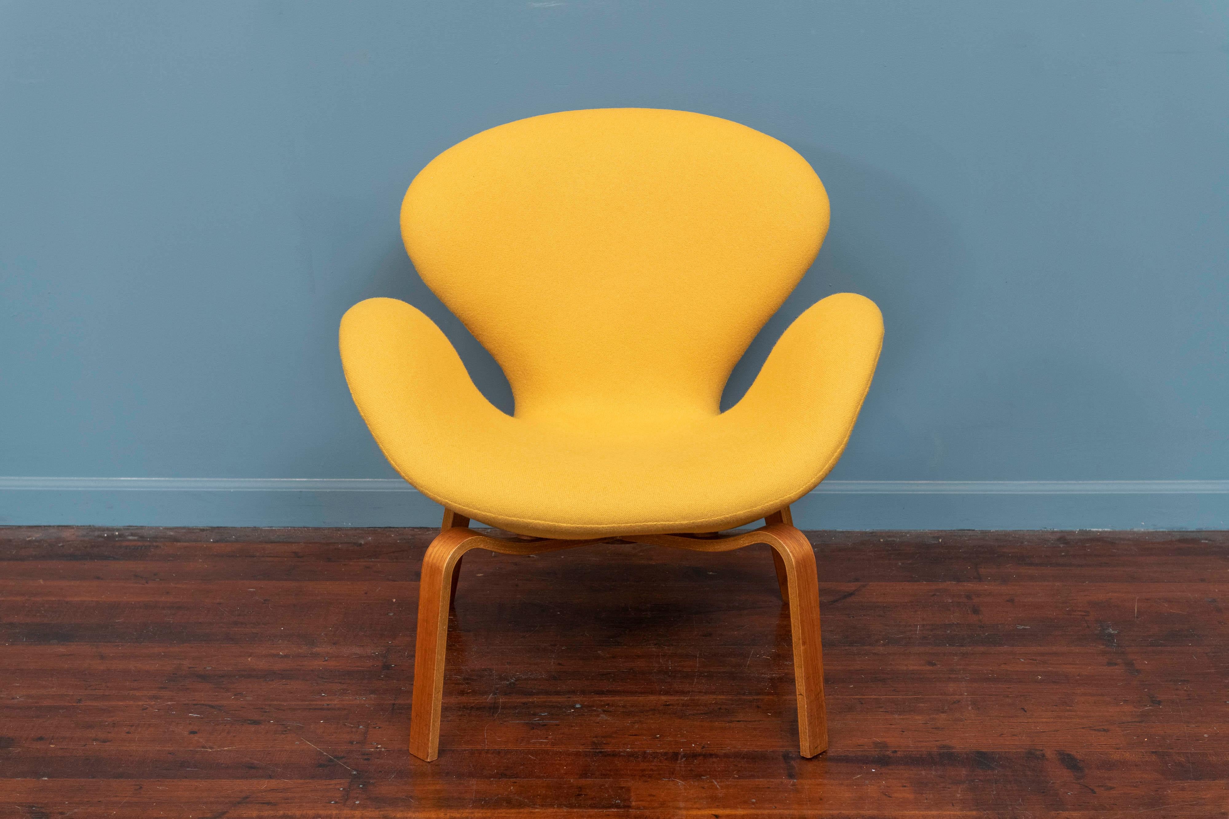 An extremely rare vintage Swan chair with a wooden frame yellow wool upholstery. While the ’swan series‘ is still in production today by Fritz Hansen, Denmark, the „wooden version“ was discontinued in 1973 and has not been in production since. Arne
