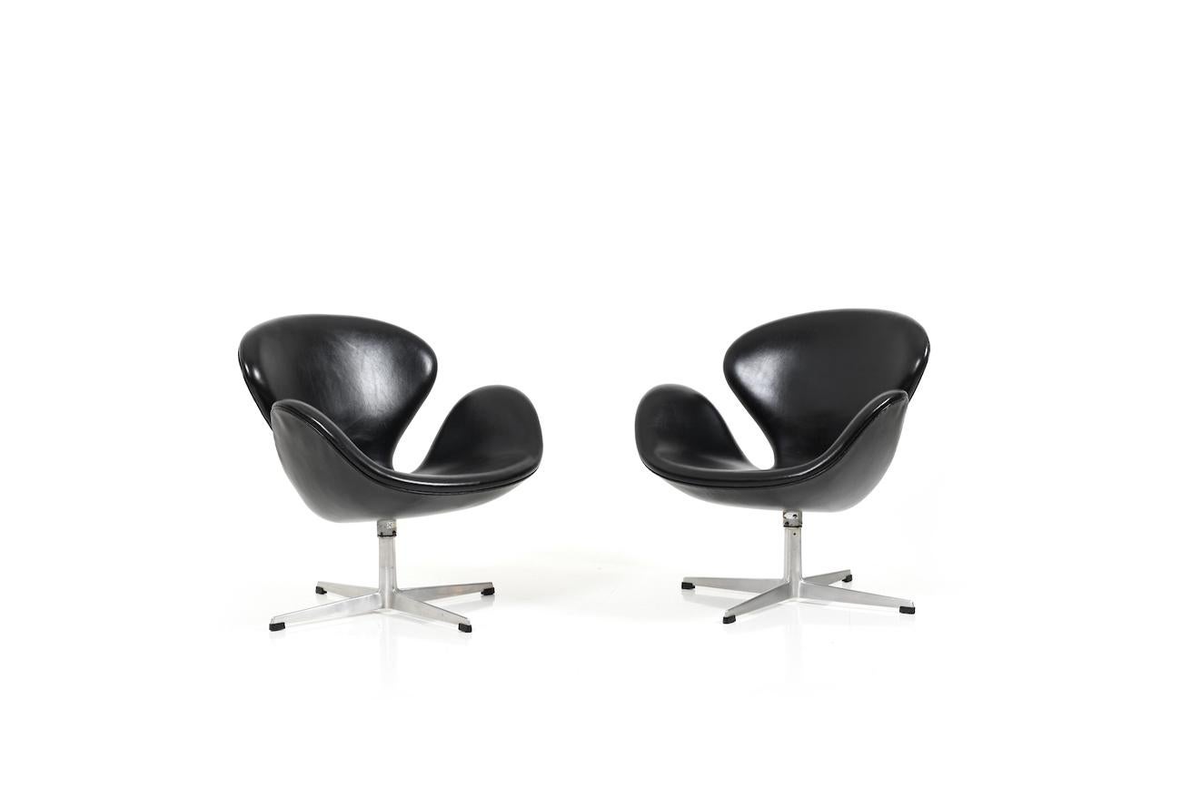 Pair of old Arne Jacobsen „The Swan“, manufactured by Fritz Hansen, 1960s. New upholstery in Denmark with fine black „Canyon“ leather from Arne Sørensen, Denmark. This beautiful leather from Arne Sørensen Denmark is characterized by its own patina.