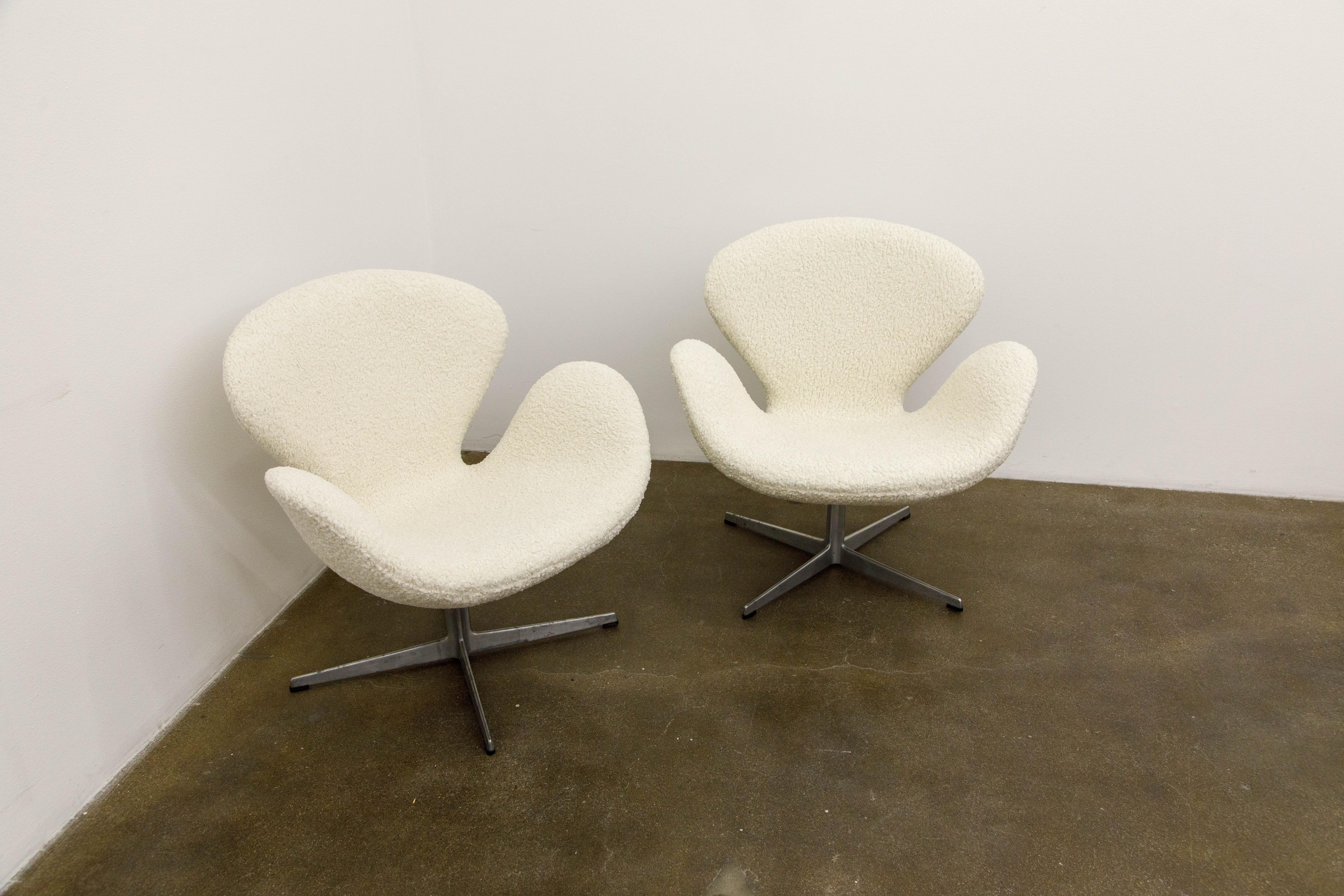 This elegant pair of early year original productions reupholstered bouclé 'Swan' swivel armchairs by Arne Jacobsen for Fritz Hansen are signed and dated January 1969 via the Fritz Hansen foil labels attached to the base of the chair as can be seen