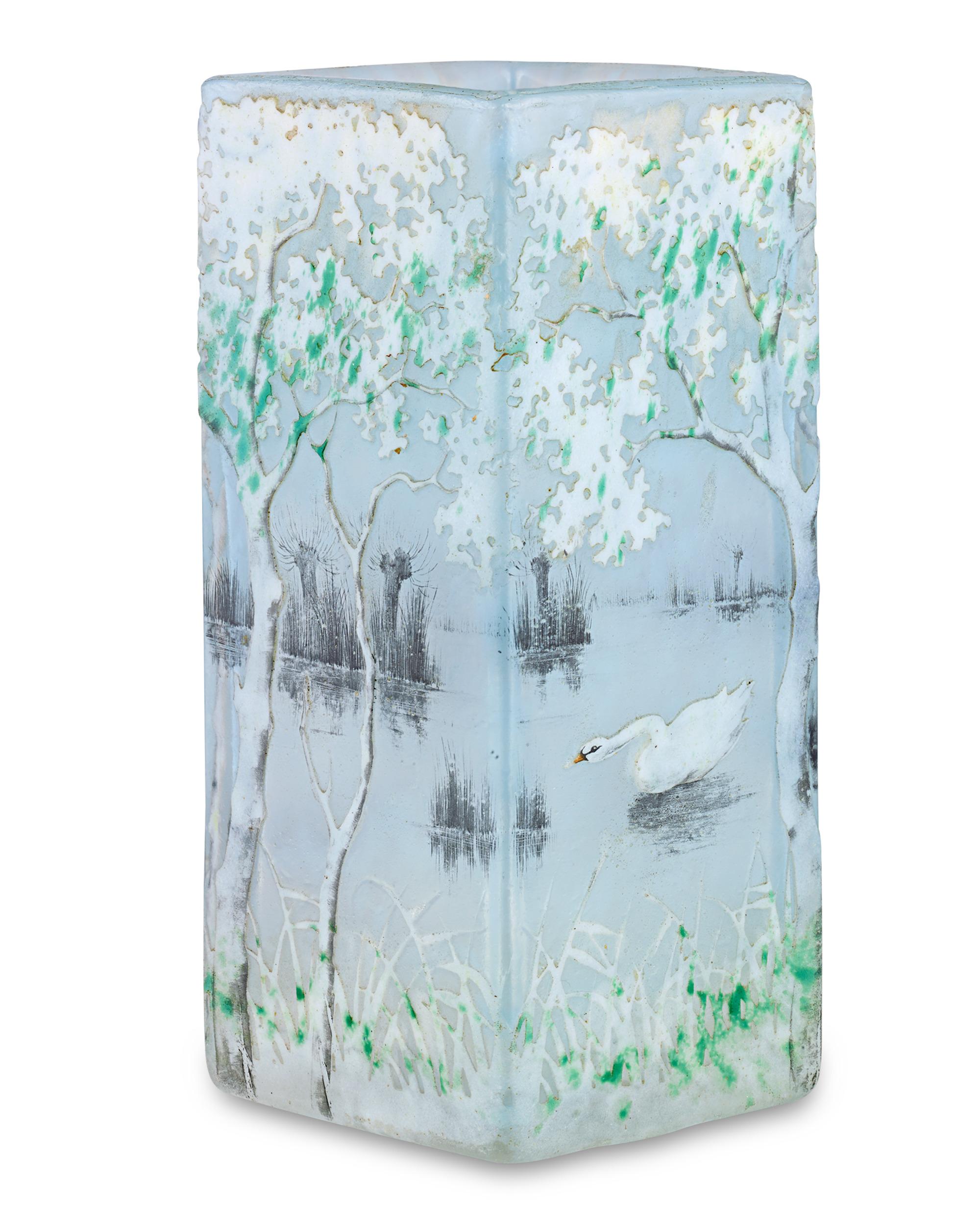 This exquisite Daum Nancy vase shows the superb quality and detail for which the firm's cameo glass is beloved. Carefully acid-etched and enameled, the vase presents a tranquil scene of a swan drifting along a lake. Colorful trees rise from the