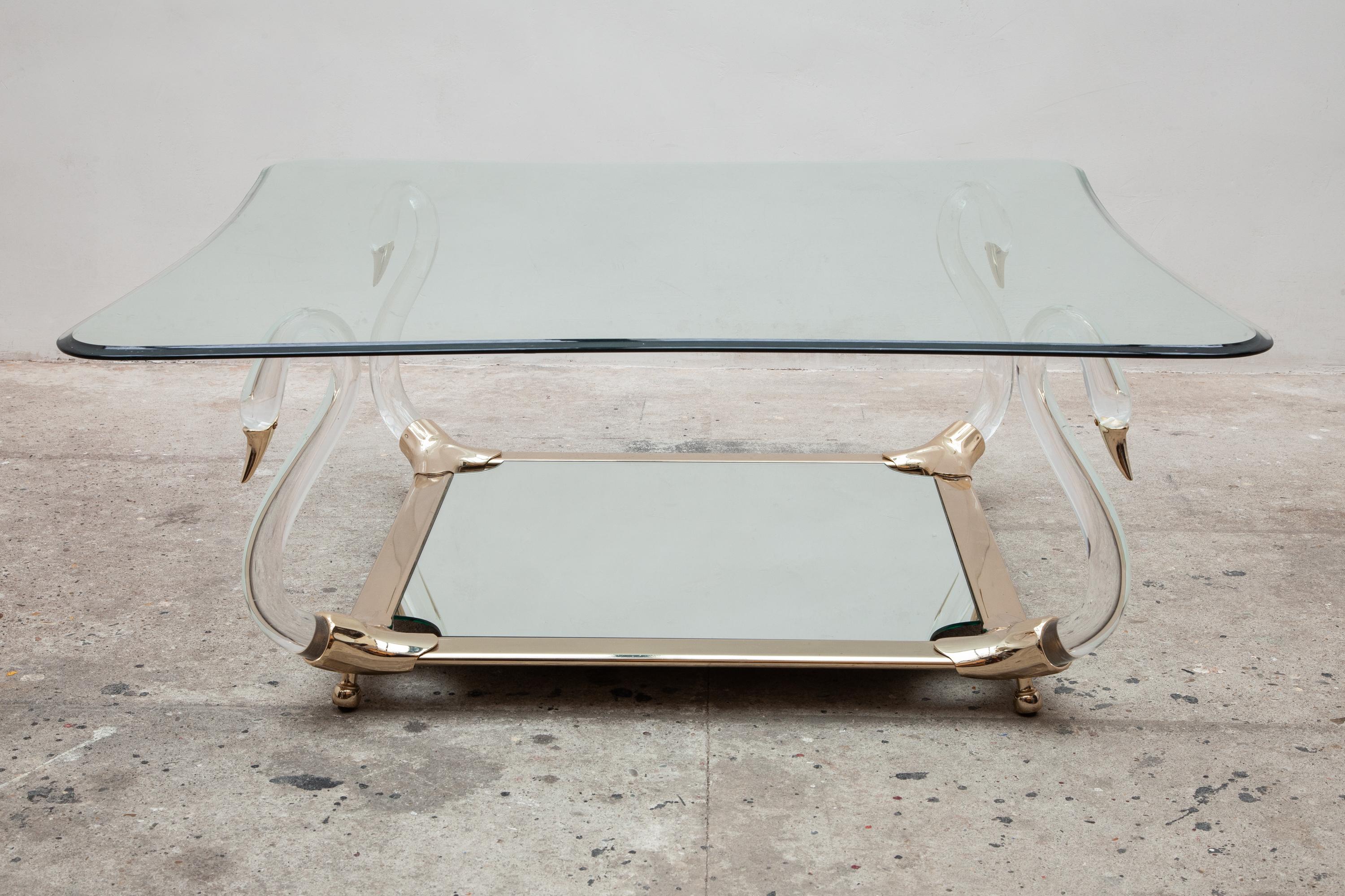 Square vintage 1970s swan table glass top coffee table with mirrored under shelf.
Features Lucite legs shaped like swan necks with gold beaks.
Measures: 109 W x 44 H x 109 D cm.

