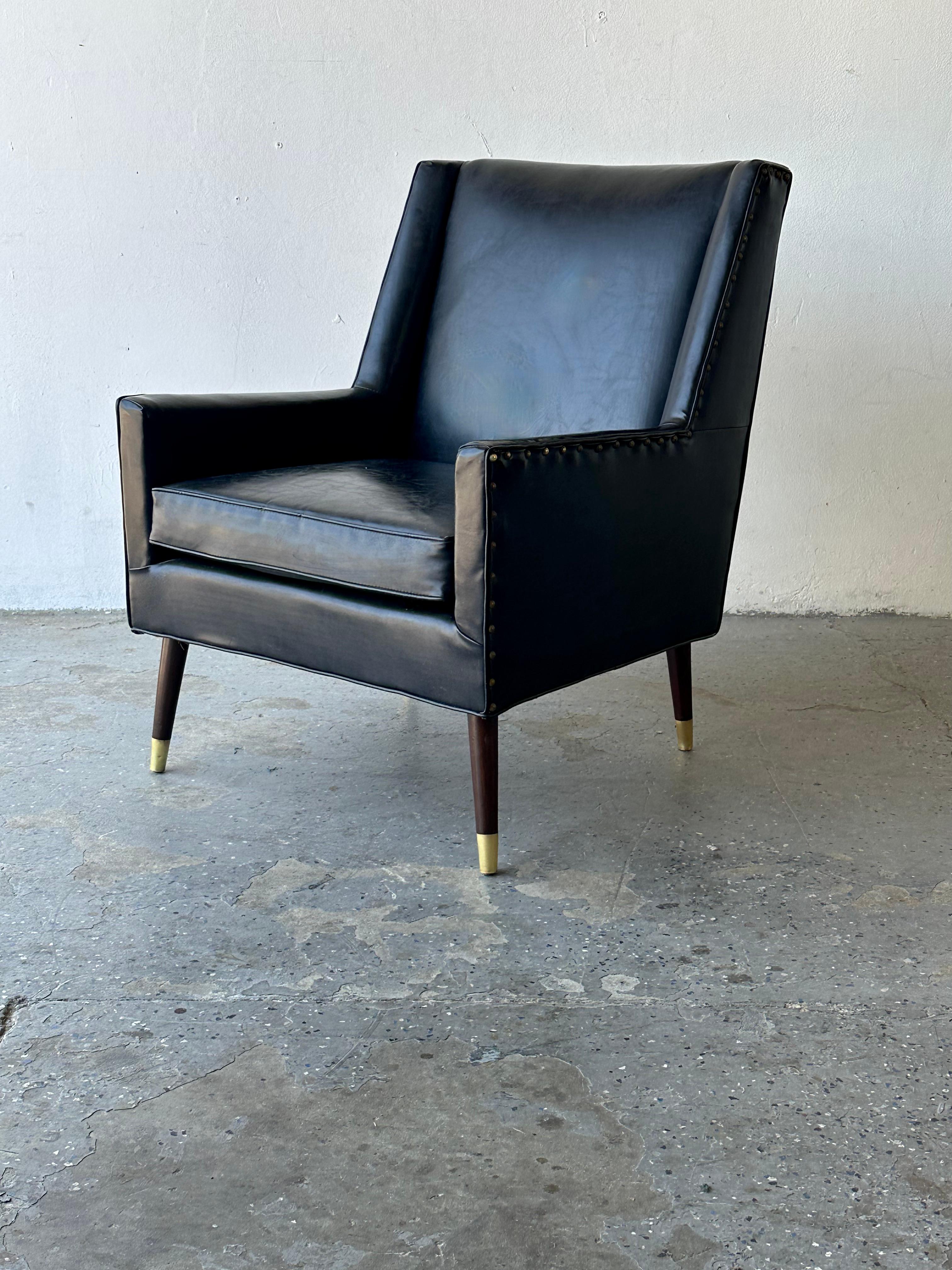 This chic 1950s Mid-Century Modern Armchair has a beautiful Classic shape and sleek wood legs with brass caps. Nice beaded detail that extends from the sides to the back, this is a beautiful piece of furniture. Every side of this chair is a pleasure