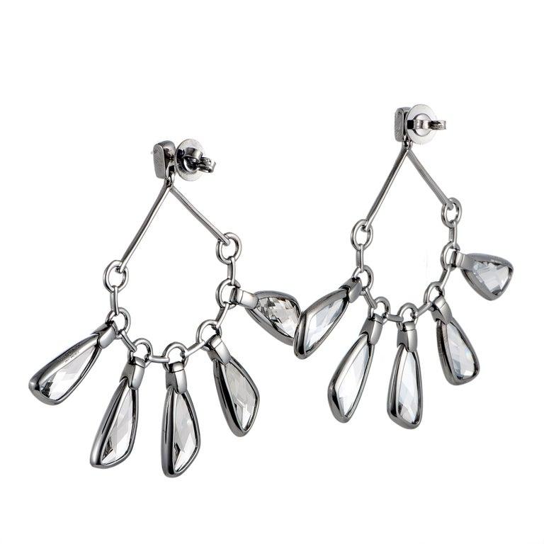 These Atelier Swarovski earrings are designed by Paul Andrew and are set with crystals. The earrings measure 2.65â€ in length and 3.00â€ in width and each weighs 12.5 grams, for a total weight of 25 grams. Offered in brand new condition, this pair