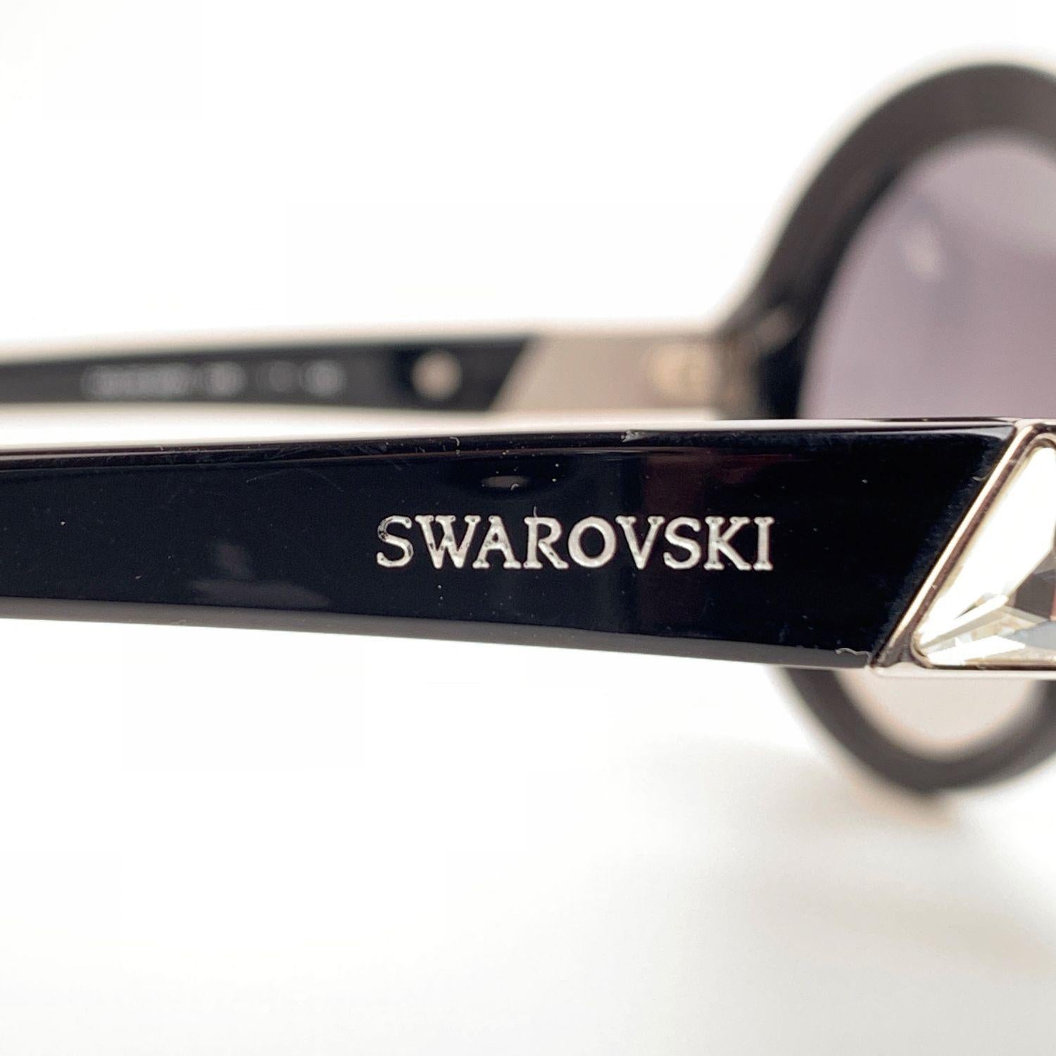 Swarovski 'Dolce SW71' Oversized round sunglasses. Large frame in black acetate with ctriangle crystals on temples. Gradient gray original lenses. Swarovski signature on temples. Made in Italy. Style & refs: Dolce SW71 - 01 B - 140