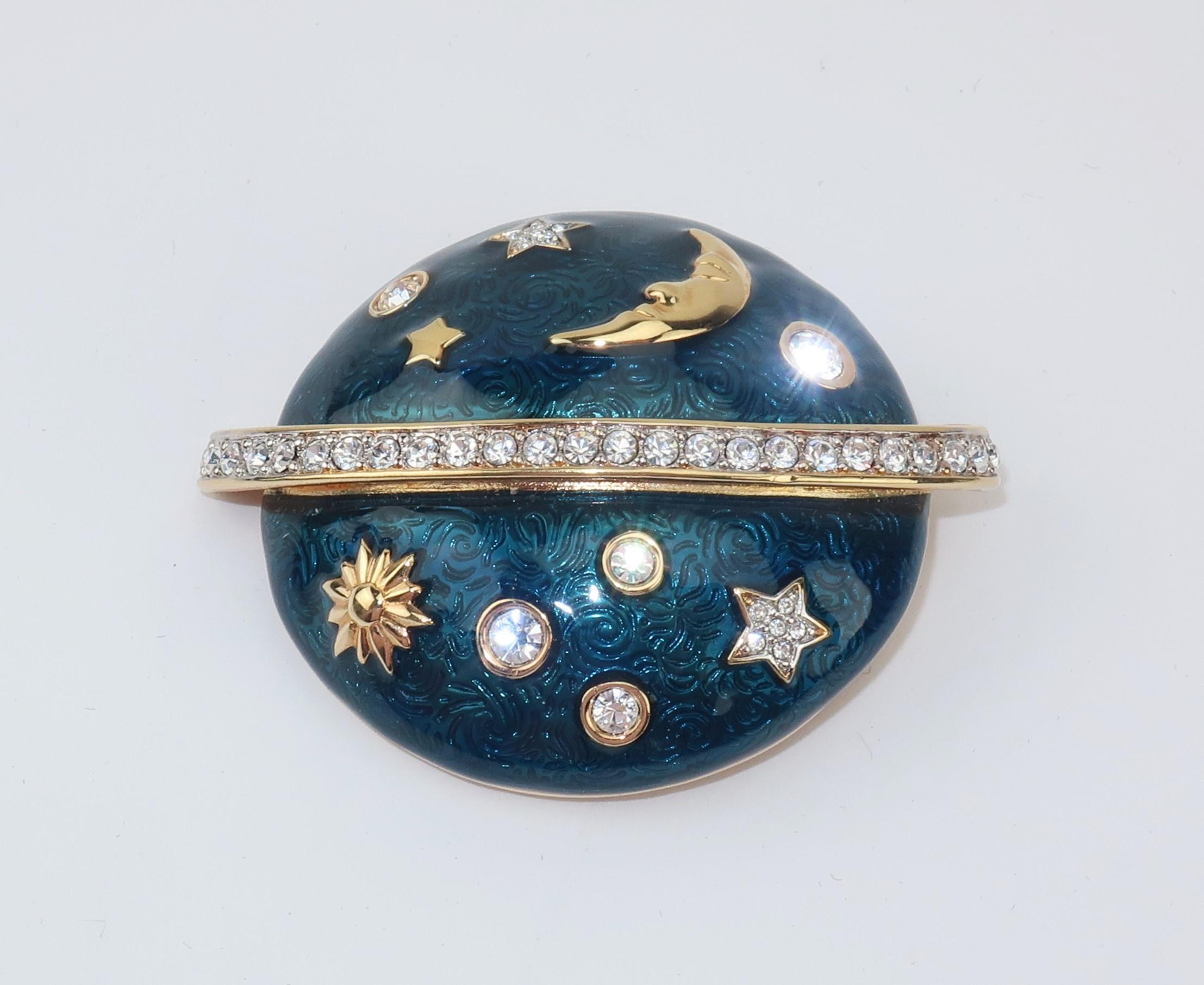 Aim for the stars and shoot for the moon!  This Swarovski crystal rhinestone encrusted brooch has gold tone stars, moons, planets and suns decorating a royal blue enamel Saturn shaped orb.  Beautifully made with attention to details including cut
