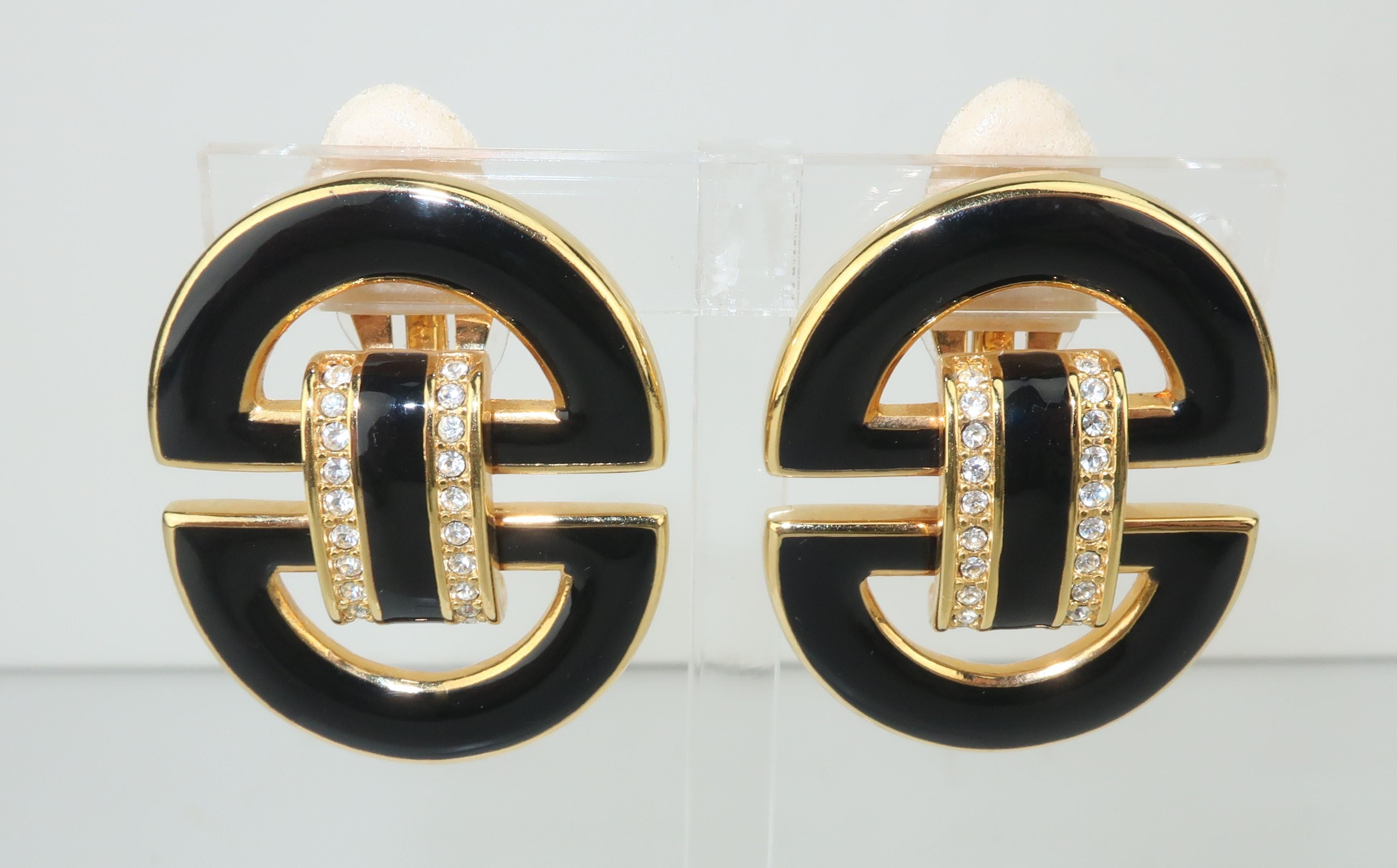 Stylish and chic Swarovski America Ltd. black enamel on gold earrings with crystal accents in a door knocker silhouette.  Outfitted with clip on hardware and hallmarked ‘S.A.L.’ at the back.  Very good vintage condition with removable pads added by