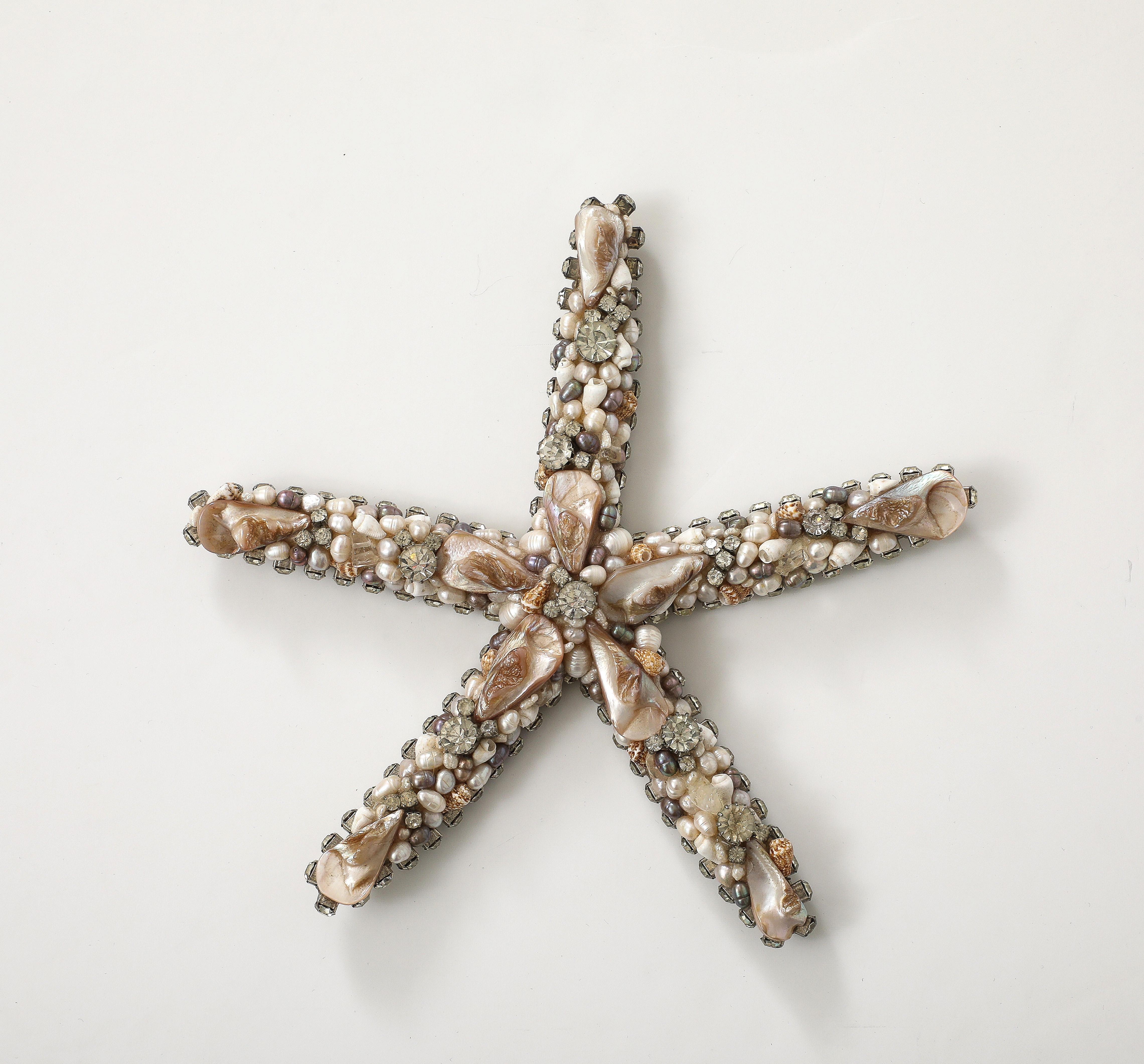 Großer Seestern mit Swarovski-Kristallen verziert und 
Miniaturmuscheln nach Künstler  Douglas Cloutier
Das Stück ist auf der Rückseite mit dem Label von Cloutier signiert.