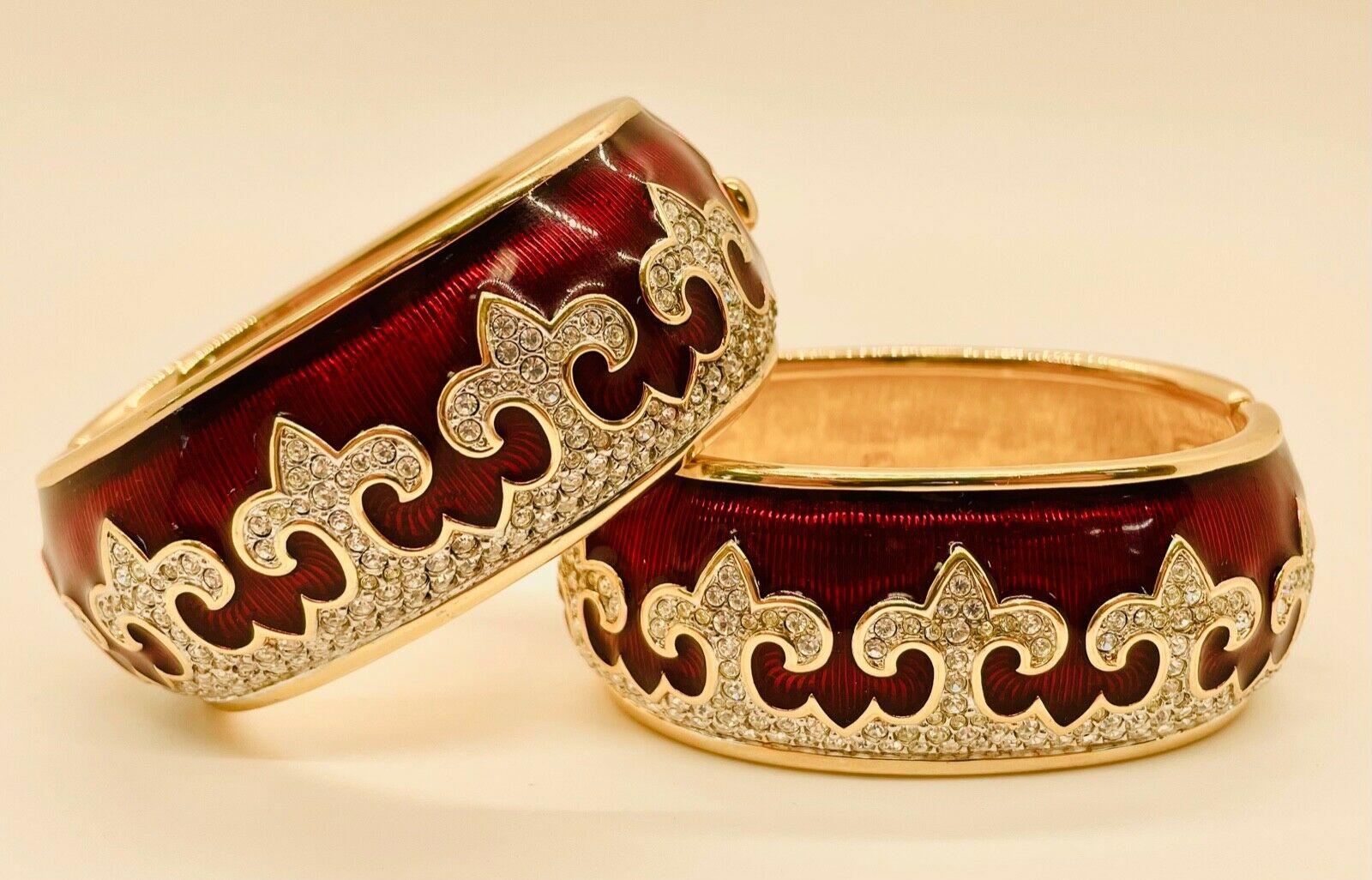 This exquisite pair of Swarovski cuff bracelets are crafted with Austrian crystals, featuring a deep red enamel-coated Guilloche background and a crystal Fleur de Lis decoration. Produced in the 1990s and stamped with the official Swarovski logo,