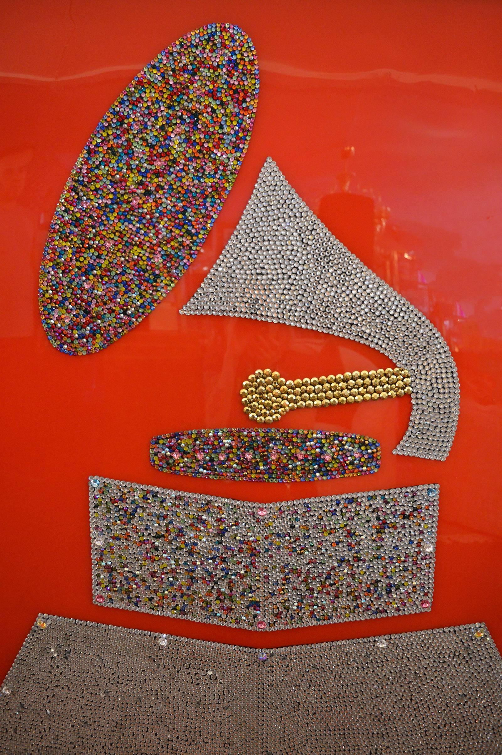 Each crystal is hand placed to create the image of the Grammy. Multicolored crystals.