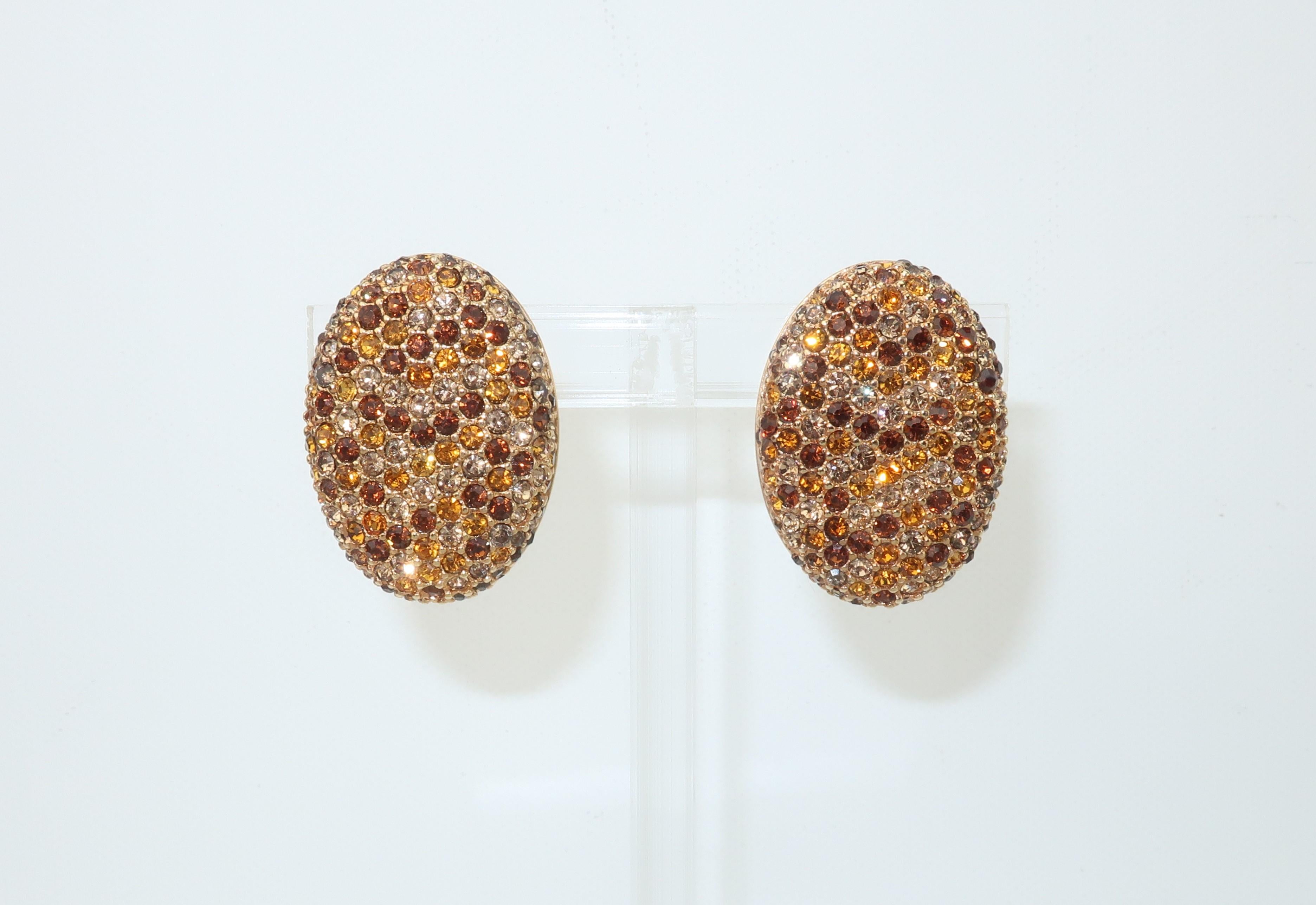 A beautiful pair of oval gold tone earrings fully embellished with Swarovski sparkling crystal rhinestones in shades of chocolate brown, amber and a grayish smoky topaz look.  The stones are set in a pattern that takes on the appearance of a