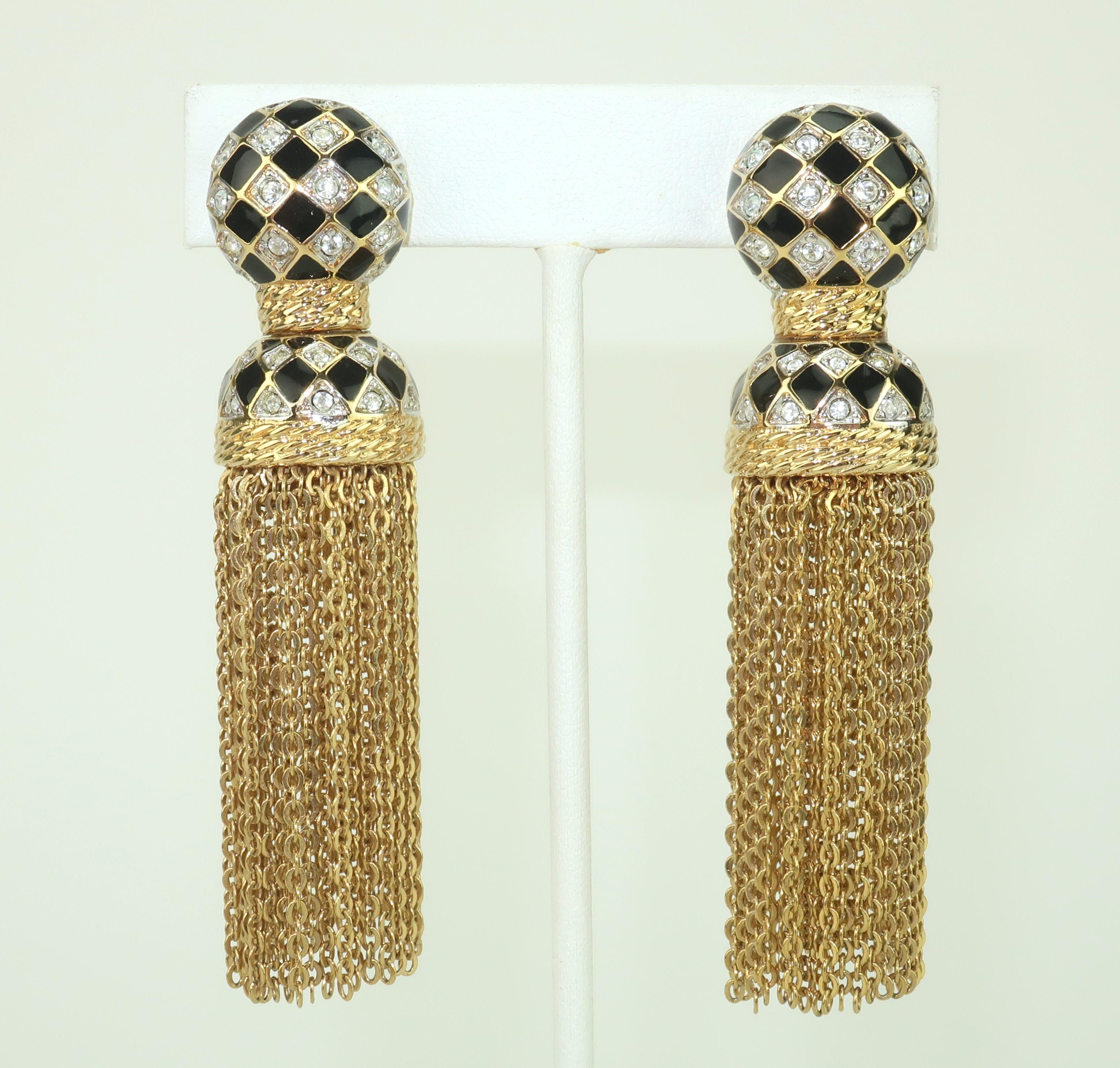 Glam and gorgeous Swarovski crystal encrusted tassel style clip-on earrings in gold plate with black enamel details.  The dangling chains provide wonderful movement and a chic look.  Hallmarked with Daniel Swarovski’s iconic swan
