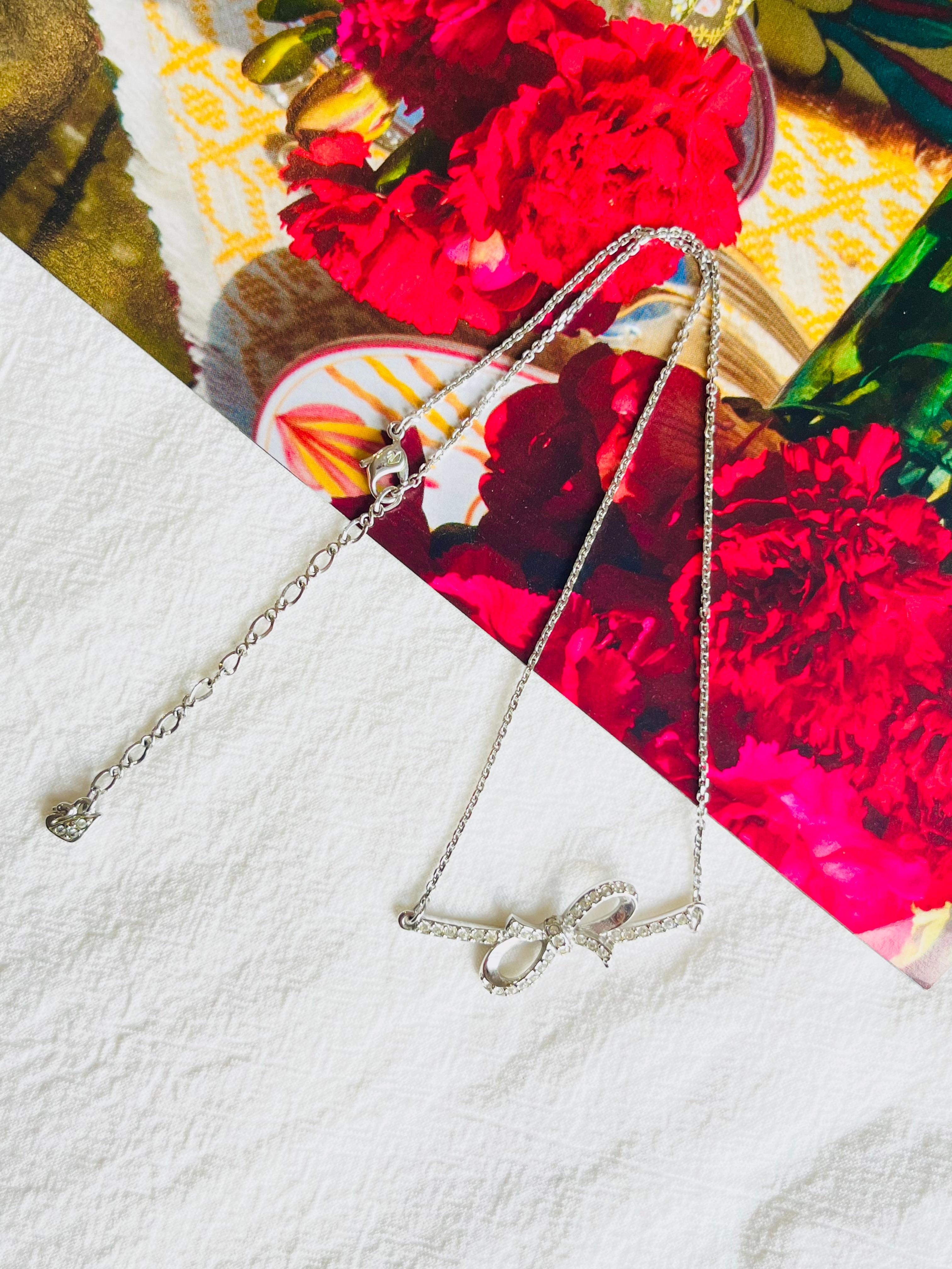 Very excellent condition and new. With box. 100% Genuine. 

The Bow collection uses the bow motif as a flirtatious and fun symbol of love. Sophisticated and modern, yet playful and youthful, this rhodium-plated necklace exudes timeless romance with