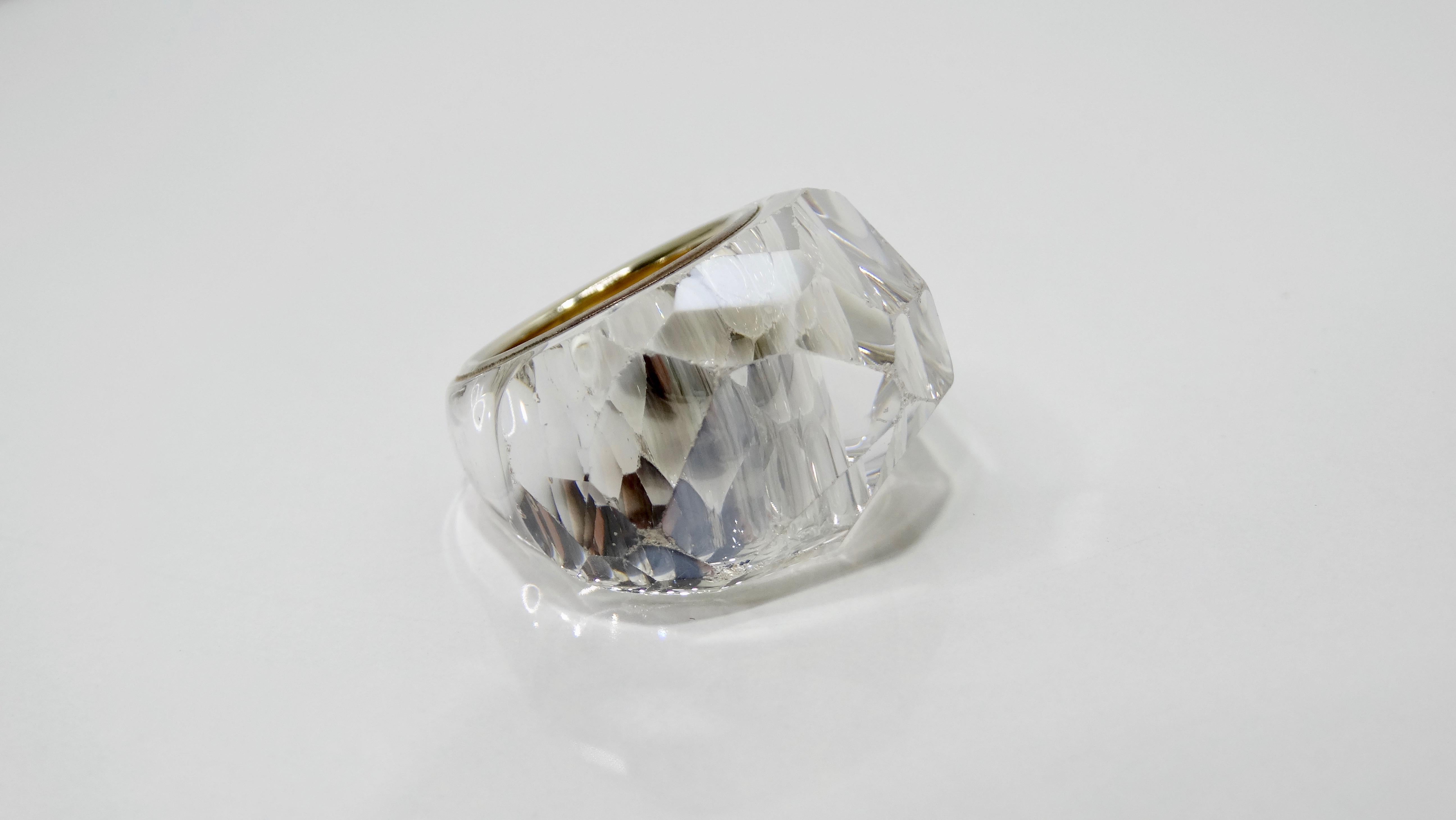 Dieser Swarovski Nirvana Ring ist ein echter Hingucker! Dieser große Ring in klarem Kristall, der 1998 eingeführt wurde, ist mit verschiedenen glitzernden Facetten versehen, die ein subtiles Herzmotiv bilden. Die Innenseite des Armbands ist mit