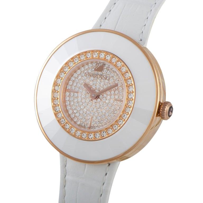 The Octea Dressy watch by Swarovski, reference number 5095383, is presented with a stainless steel case that measures 36 mm in diameter. The case is water-resistant to 30 meters and mounted onto a white leather strap, secured on the wrist with a