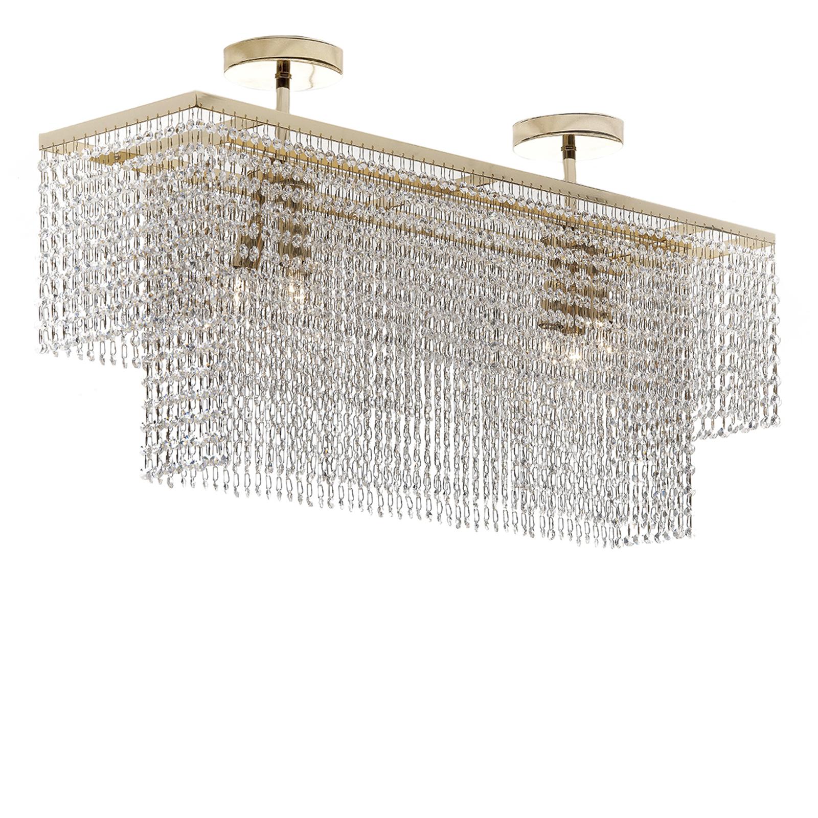 This exquisite chandelier is inspired by the bold sophistication of the Art Deco style. The supporting structure is made entirely of metal with a gold finish. The inner part consists of two round bases, each of which supports a vertical element with