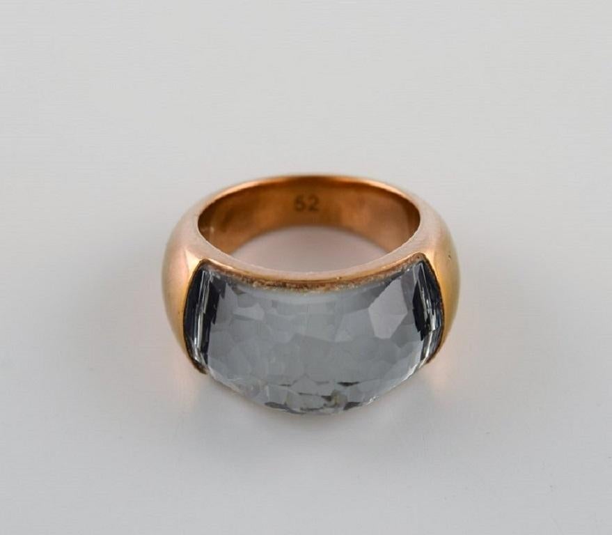 Swarovski signet ring in gold tone adorned with smoky quartz.
Original box included.
Diameter: 16 mm.
US size: 5.5.
In excellent condition.
Stamped.
In most cases, we can change the size for a fee (USD 50) per ring.