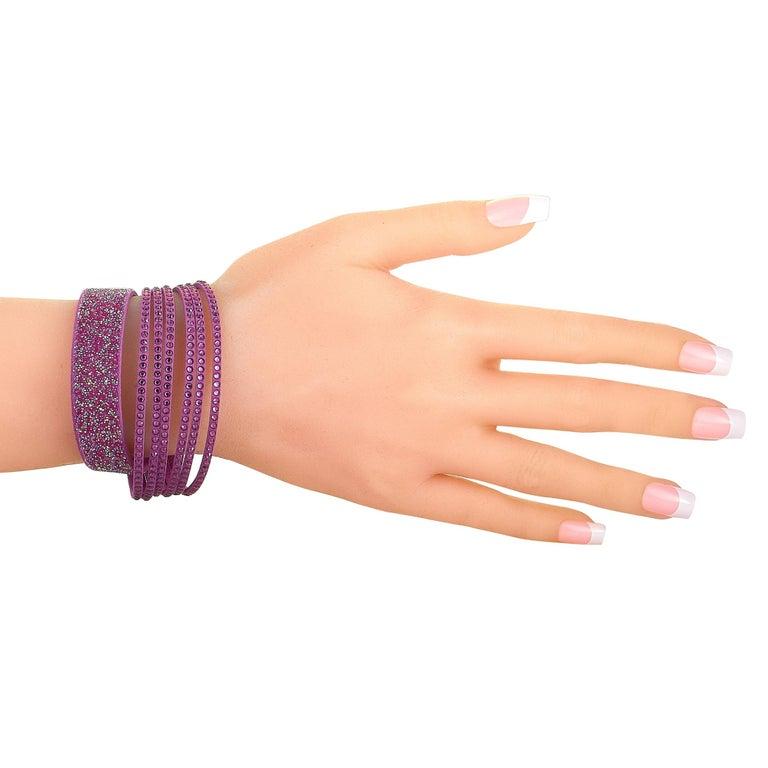 The Swarovski â€œSlakeâ€ bracelet is made of purple fabric and decorated with a plethora of crystals. The bracelet weighs 10.7 grams and measures 7.75â€ in length. This jewelry piece is offered in brand new condition and includes the