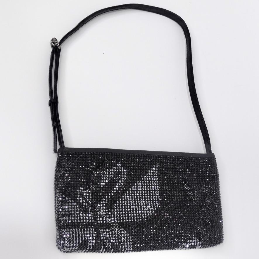 Do not miss out on this rare Swarovski embellished handbag! Classic black mini shoulder bag is covered in Swarovski rhinestones and features an adjustable buckle strap which allows for versatility with wear. The focal point of the handbag is the