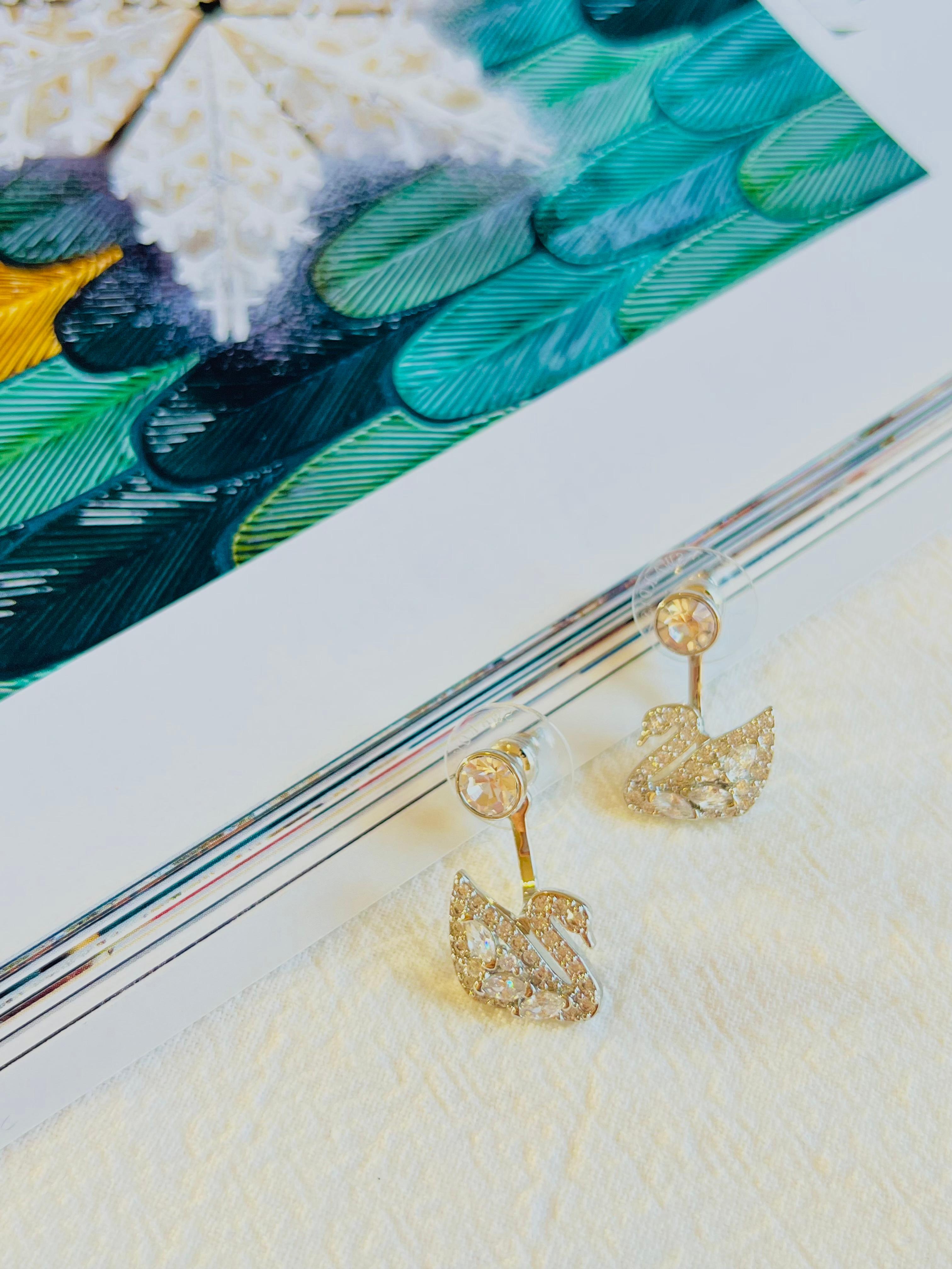 Come with original box and certificate. 100% Genuine. 

This versatile pair of pierced earring jackets is feminine and sophisticated. Wear the rhodium-plated crystal studs alone or add the dangling swans, embellished with pavé and marquise-shaped
